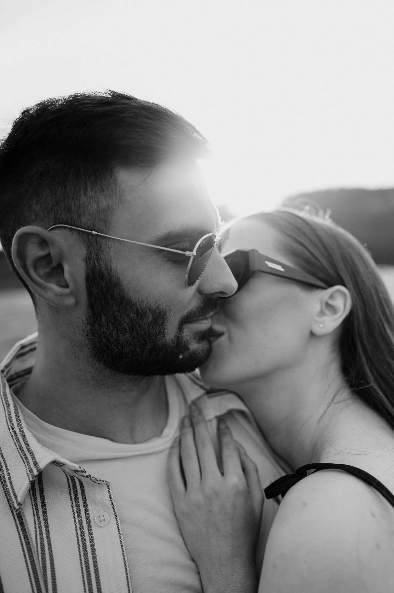 A romantic black and white photo sequence showing a couple sharing an intimate kiss.