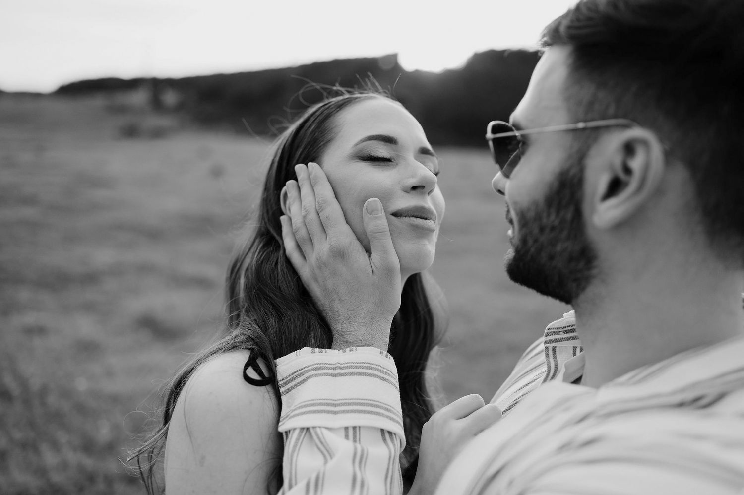 Black and white photo collage showing intimate romantic moments between a couple in an outdoor setting.