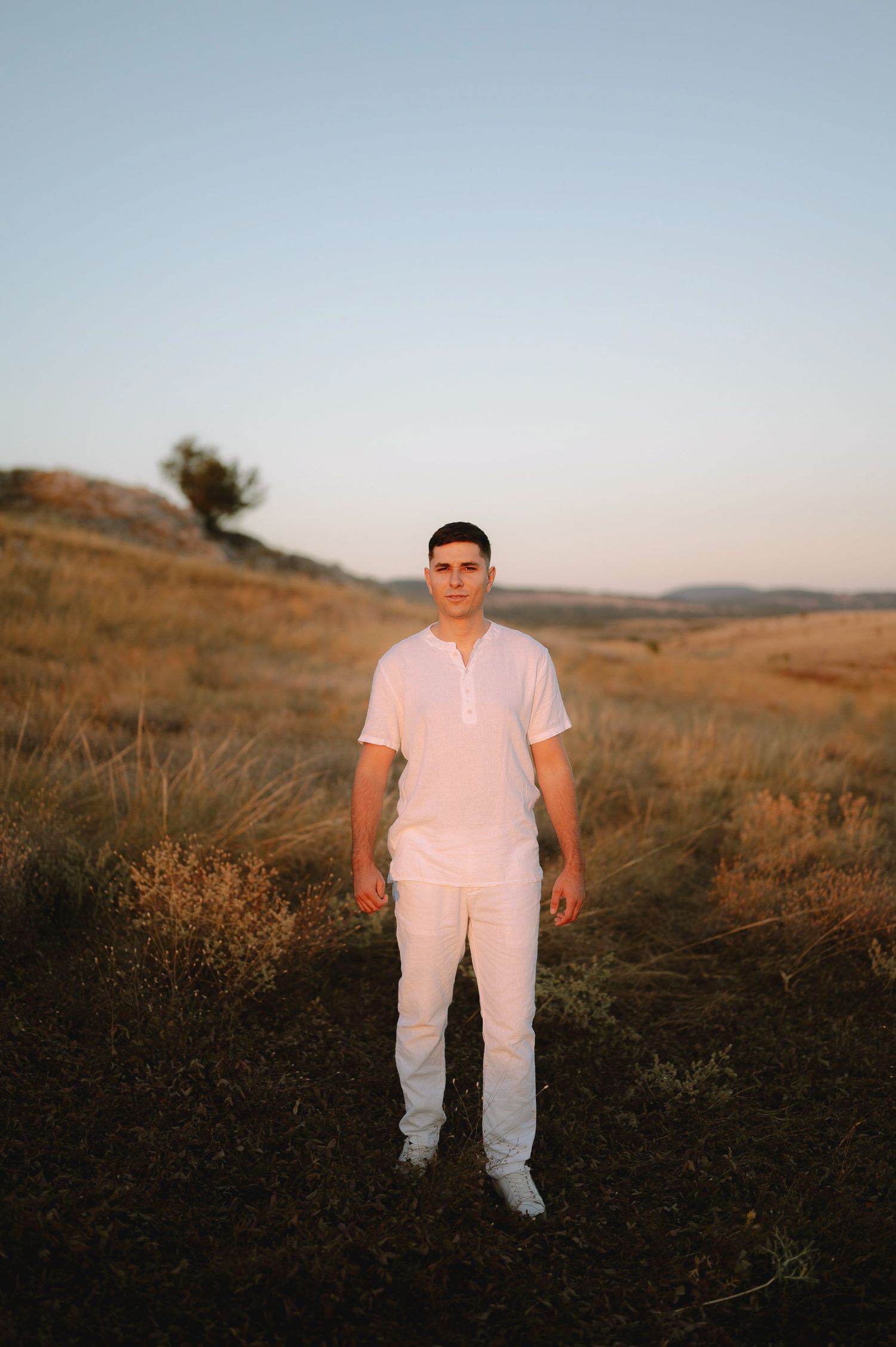 Four sequential photos show a person in white clothing standing in a golden grassy field at sunset.