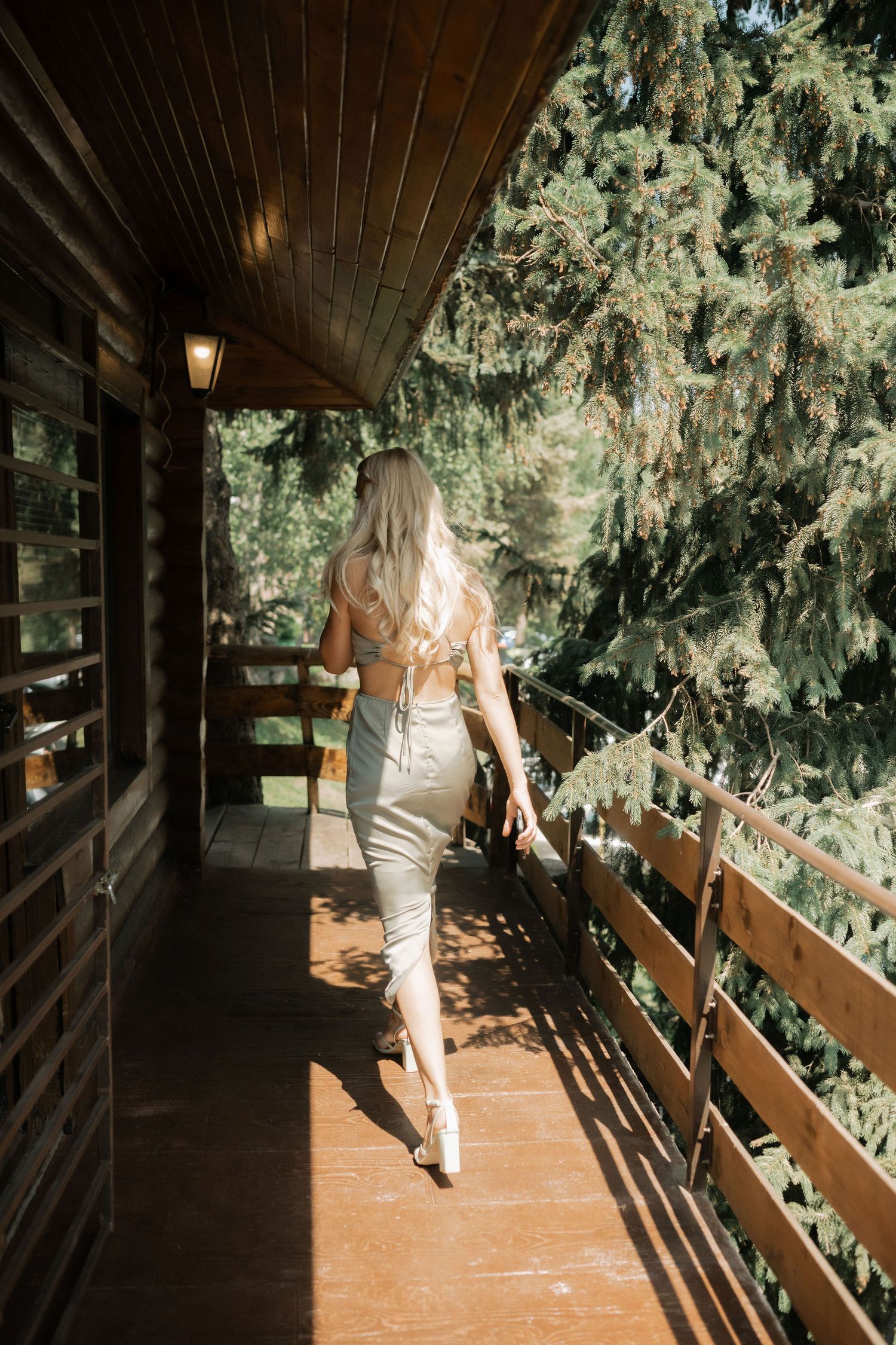 A sequence of photos showing someone walking along a wooden deck surrounded by evergreen trees in natural lighting.