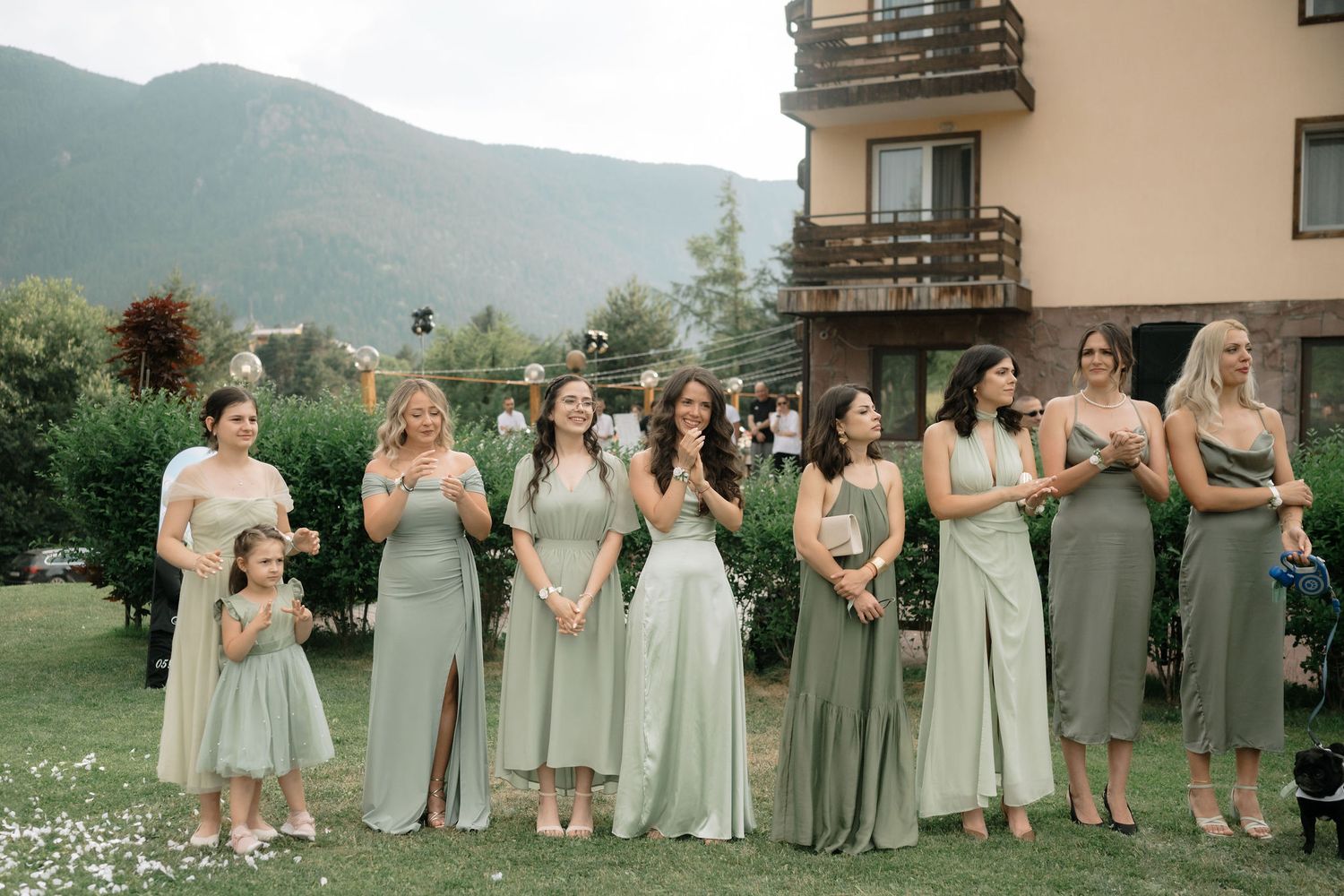 Bridesmaids in soft pastel dresses line up for group photos at outdoor mountain venue.