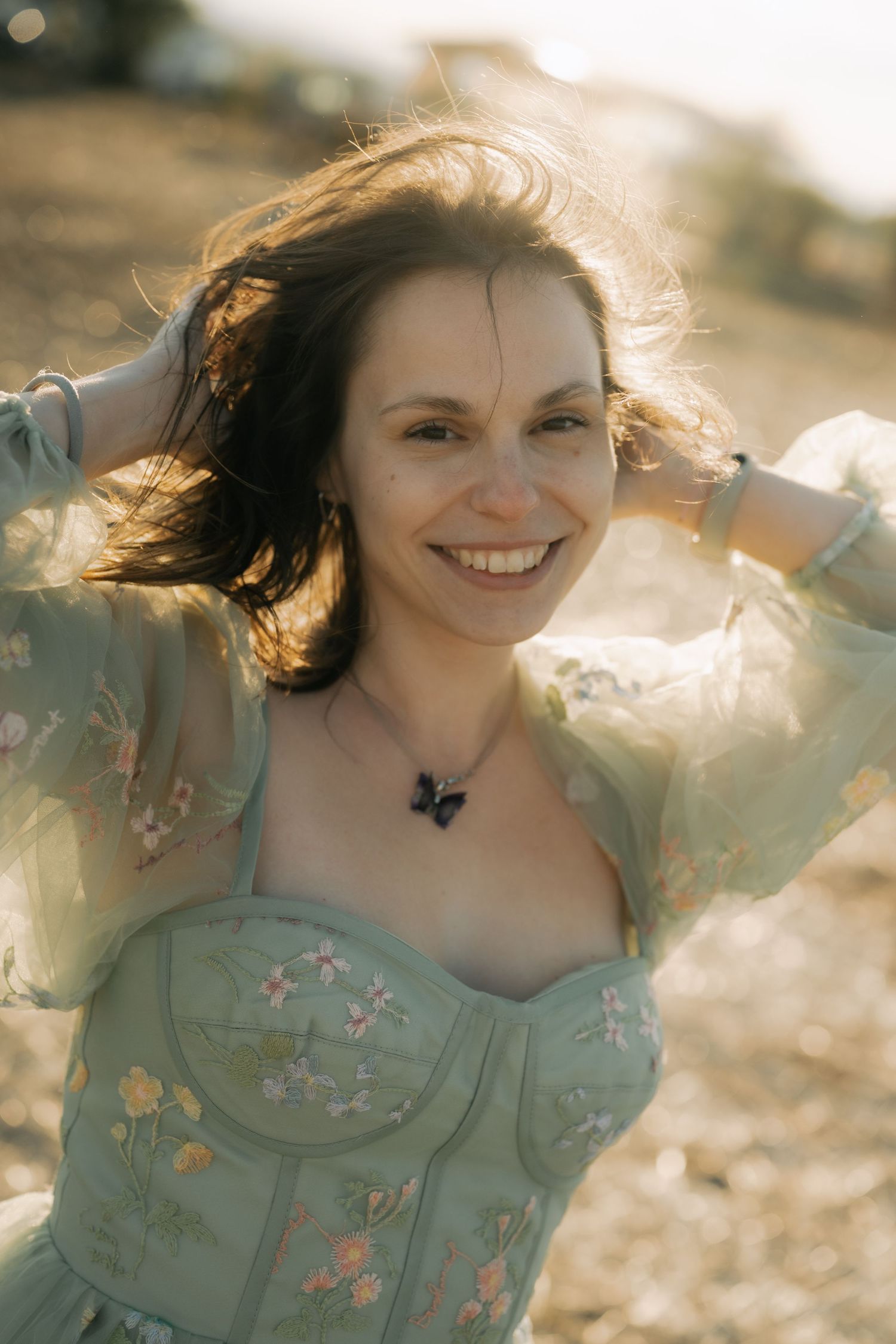 A series of dreamy portraits showing a person in a mint green floral dress with windswept hair at sunset.