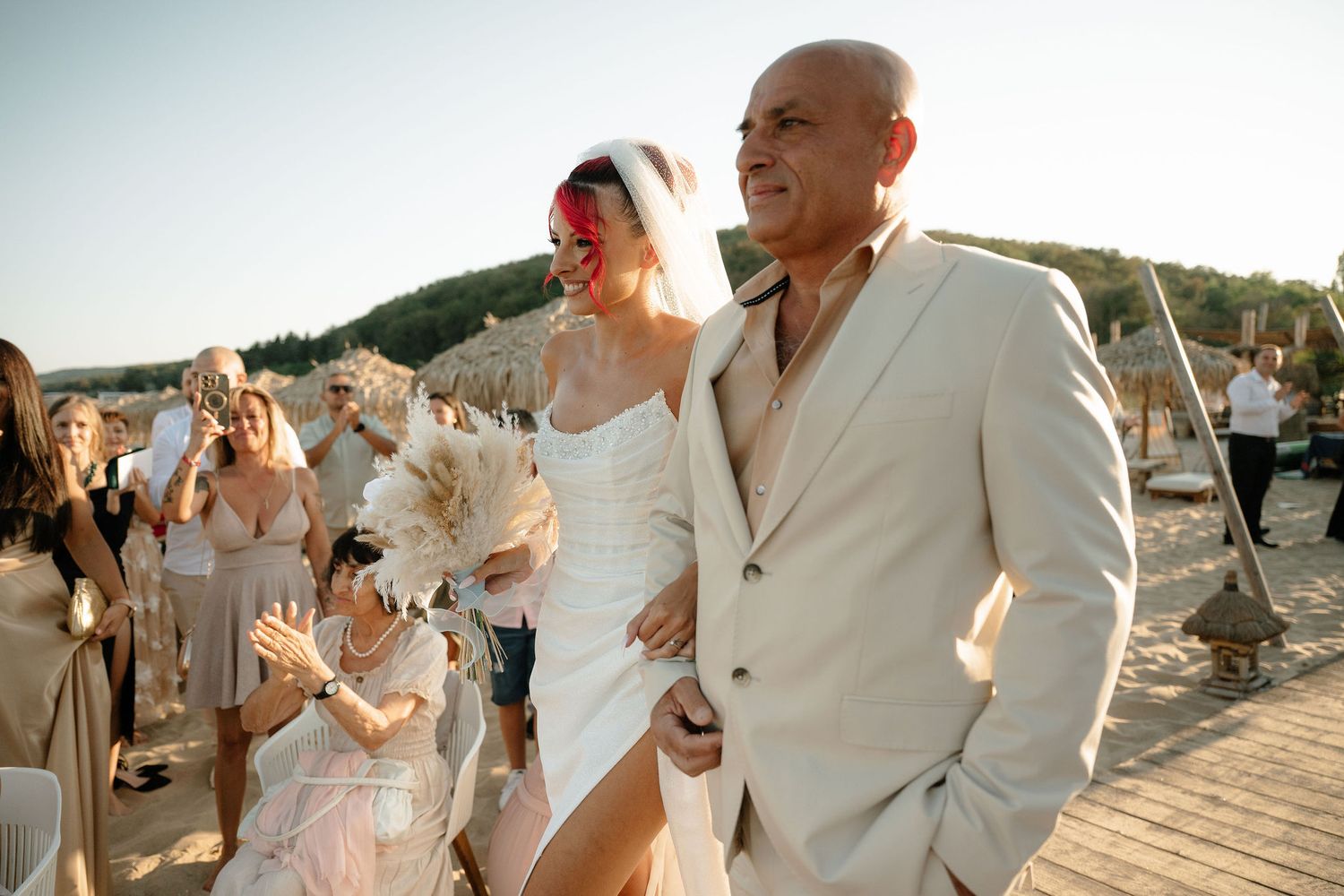 Newlywed couple shares a joyful moment during their beach wedding ceremony at sunset.
