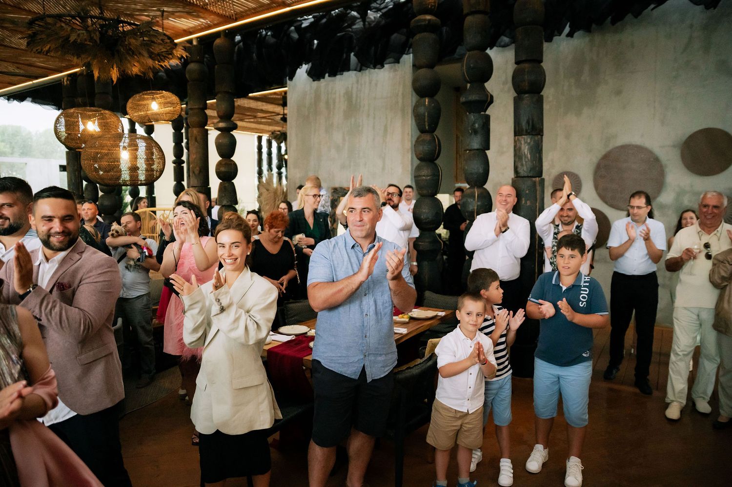 Wedding guests line both sides of an industrial venue during a celebration moment.