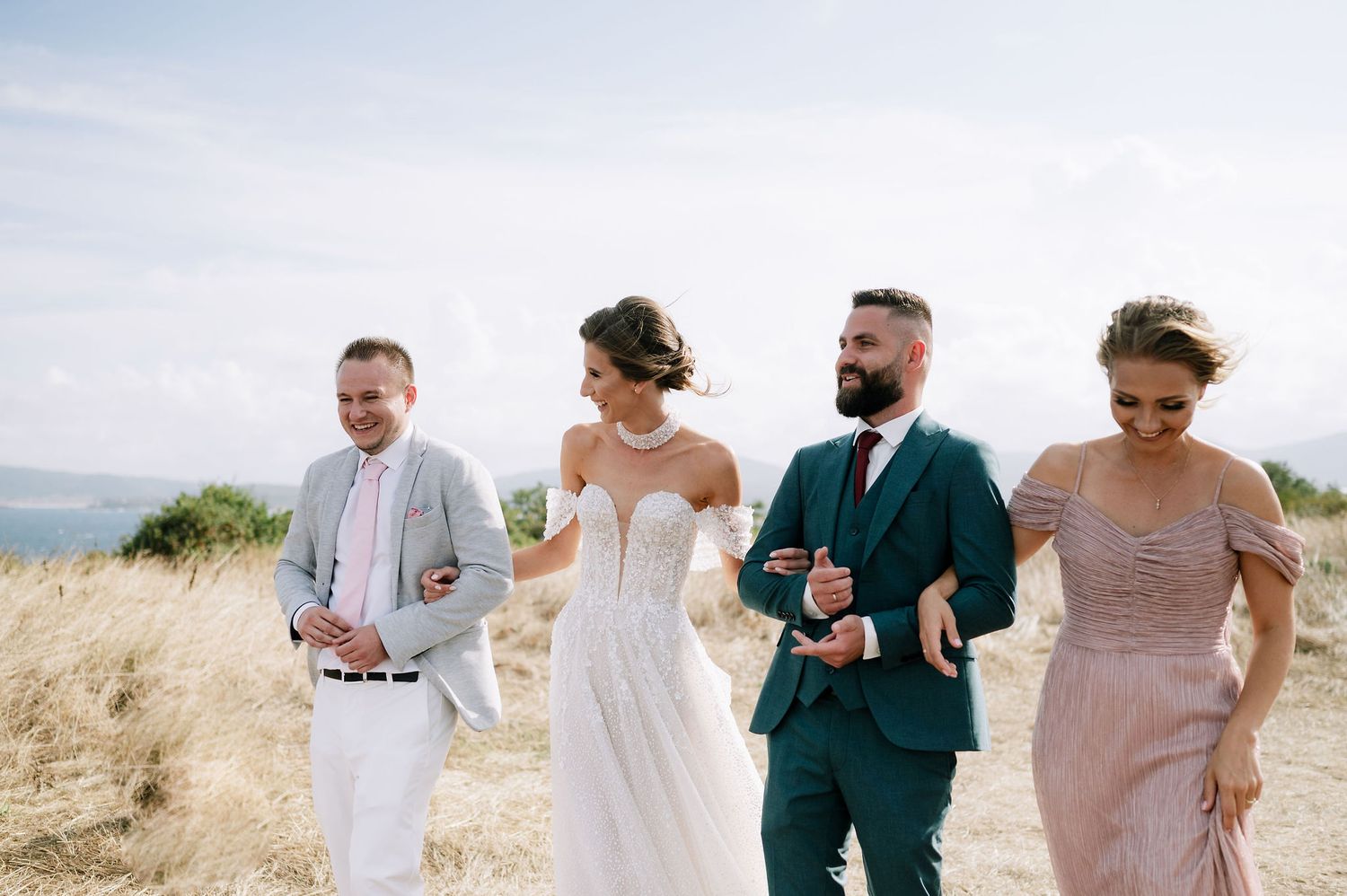 Wedding group walking and chatting casually in an outdoor setting.