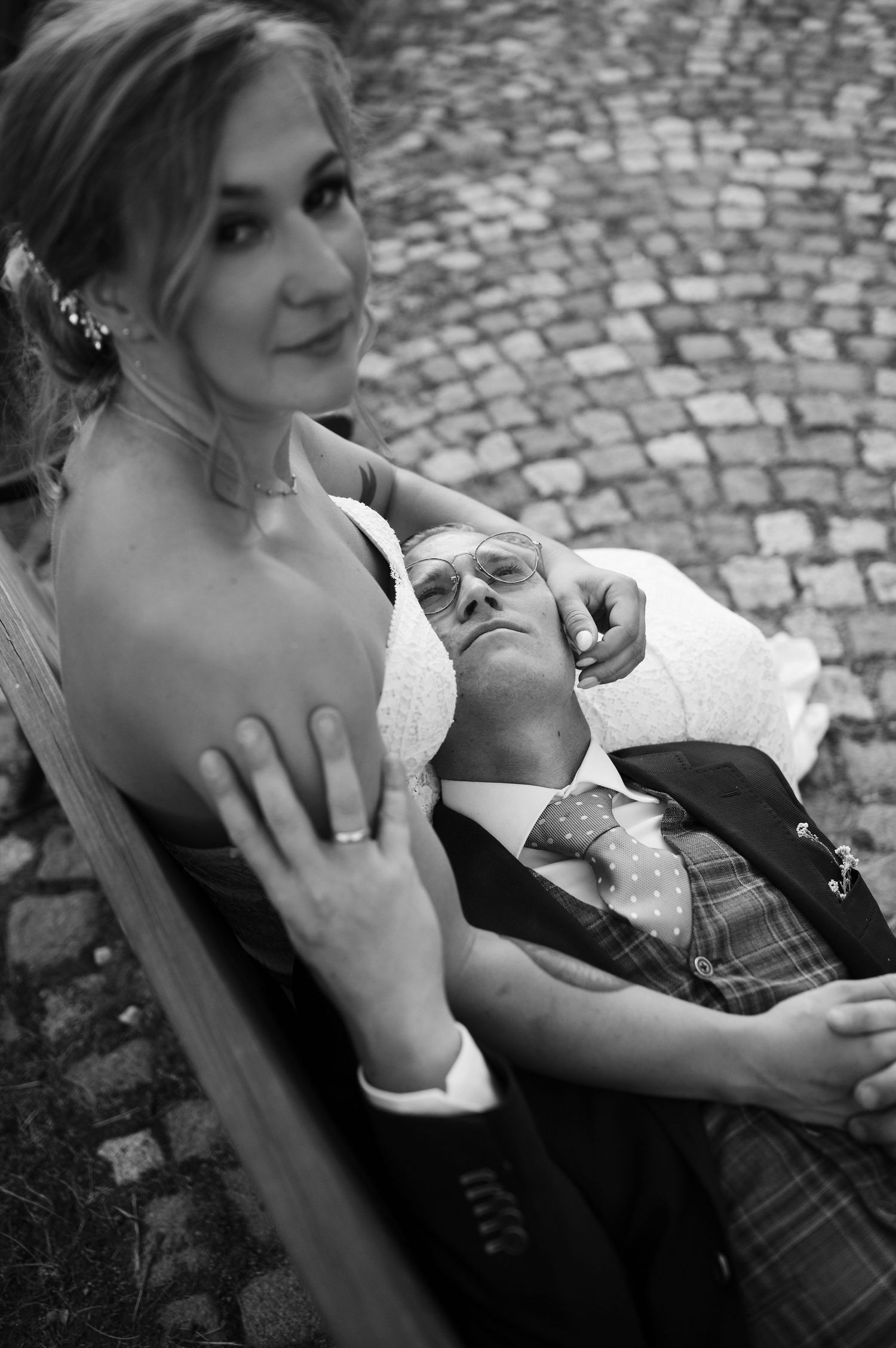 Black and white romantic portraits of newlyweds sharing tender moments on a garden bench.