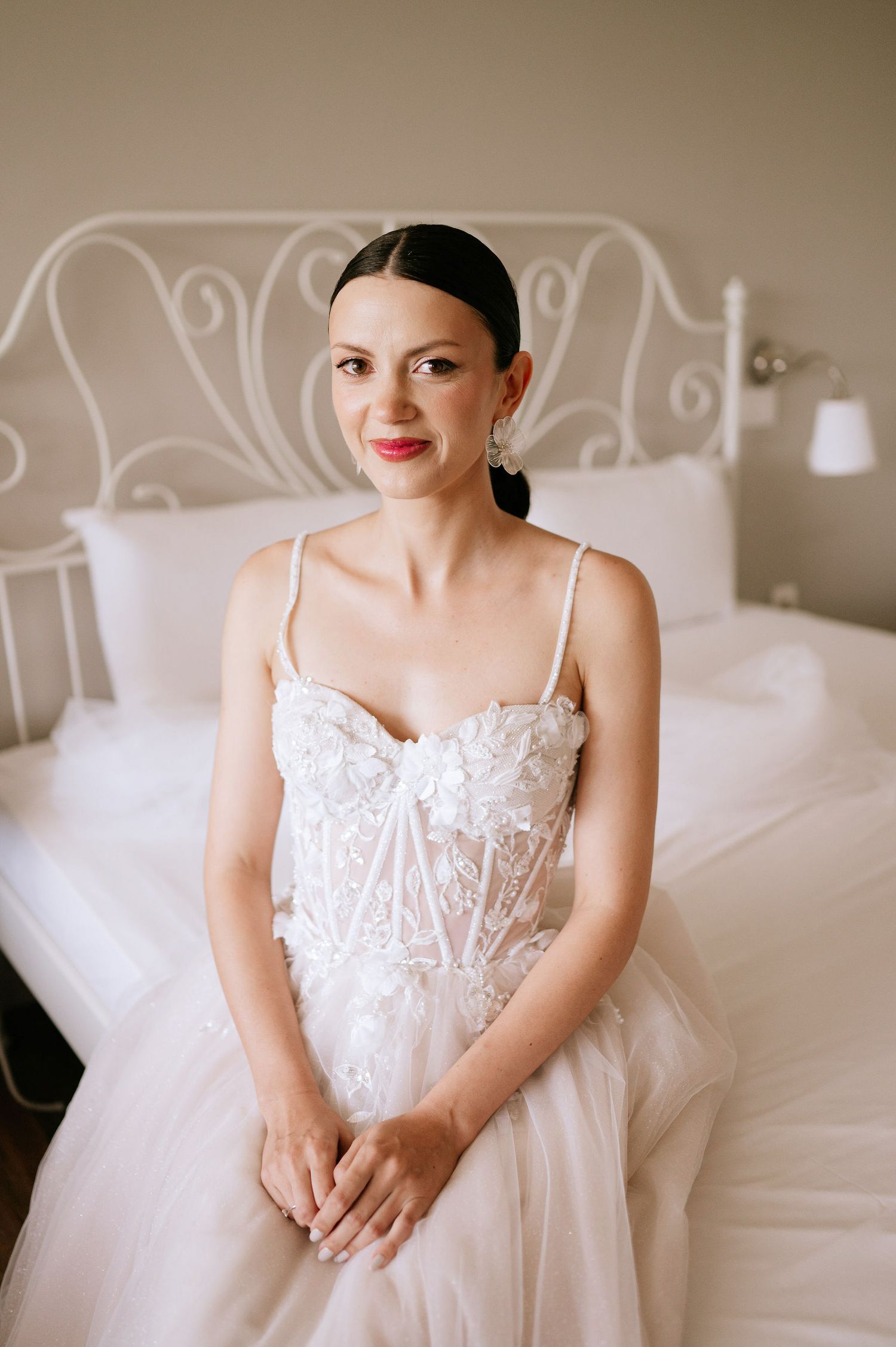Elegant bridal portrait showcasing detailed bodice of white wedding gown in soft natural light.