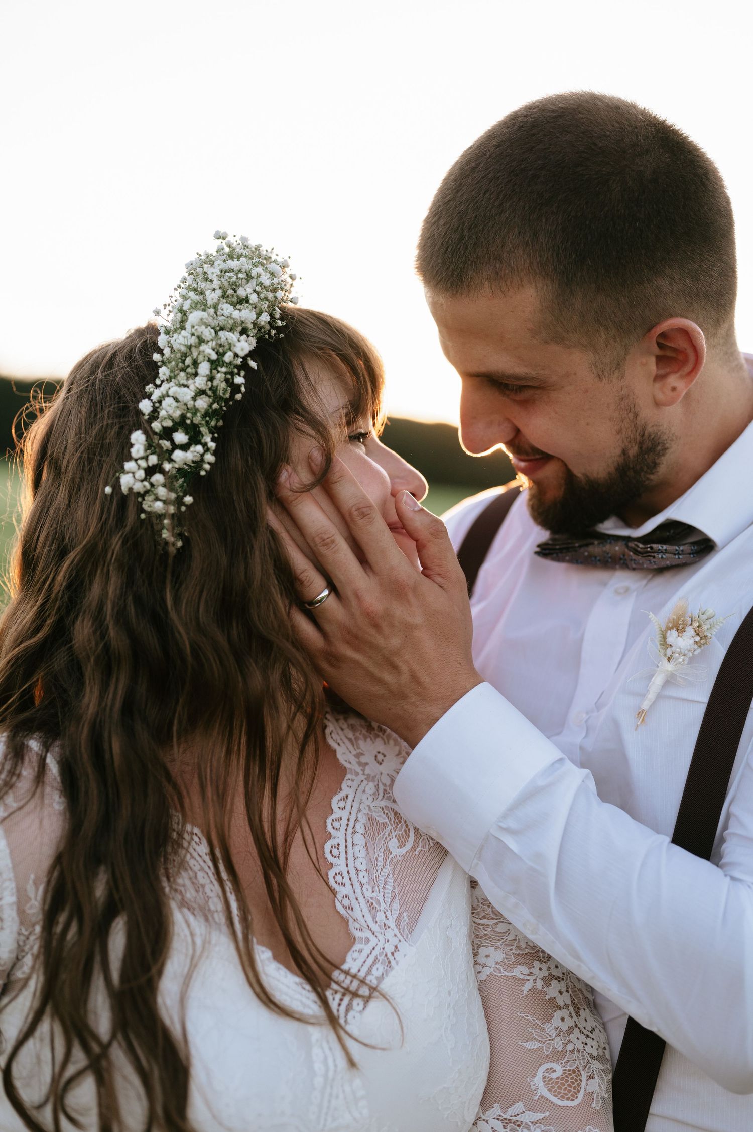 Romantic sunset wedding portrait with delicate baby's breath flowers in bride's hair.