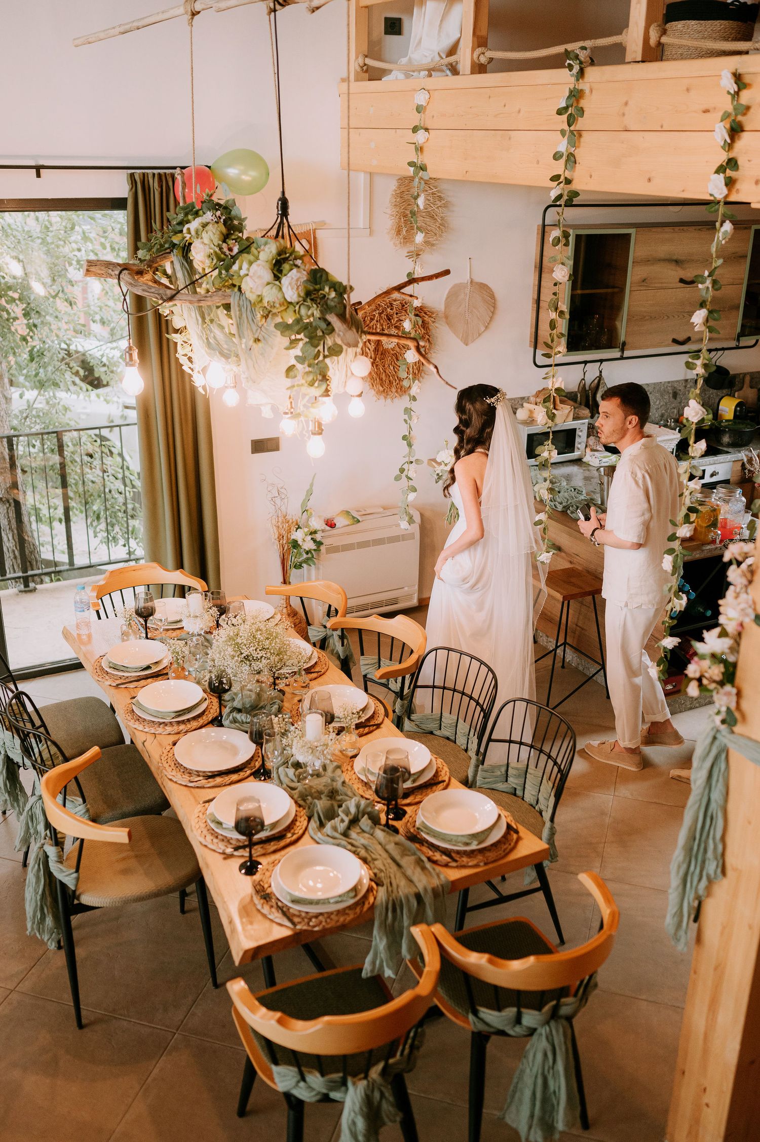 Beautifully decorated wedding dining area with hanging greenery and romantic lighting.