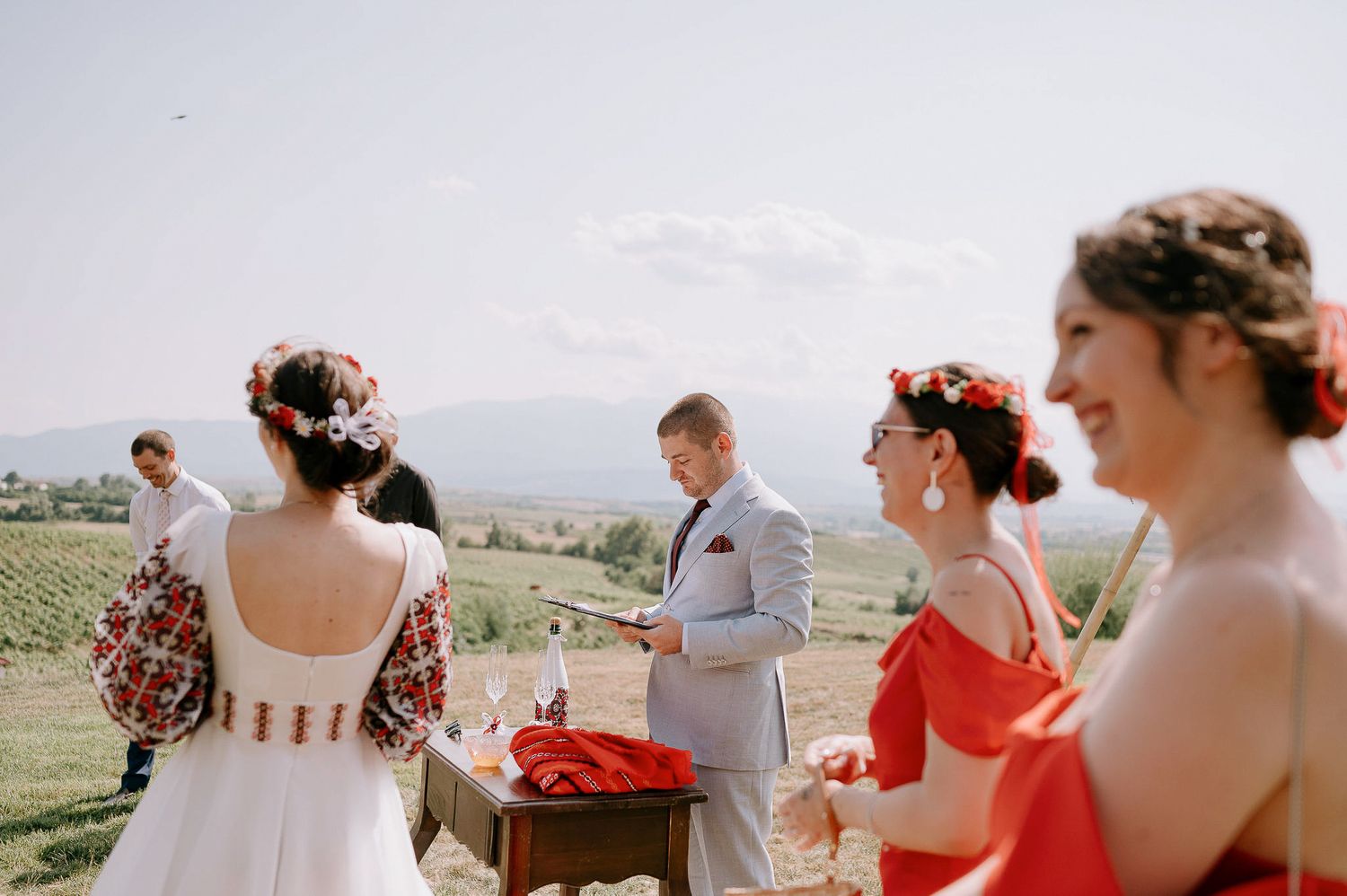 Wedding party members in red and white attire celebrating outdoors.