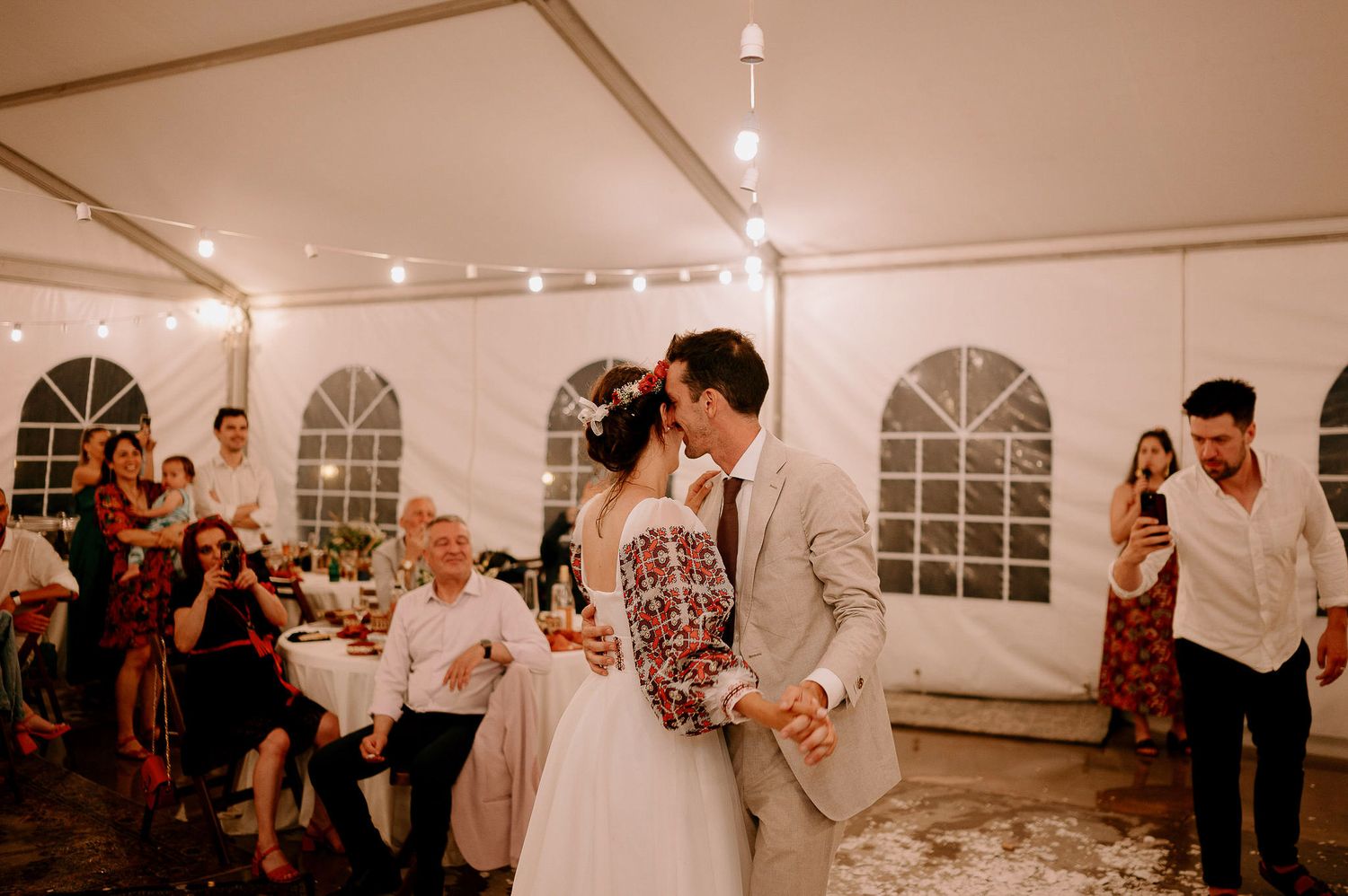 Celebratory dance moves at a wedding reception inside a beautifully lit tent venue.