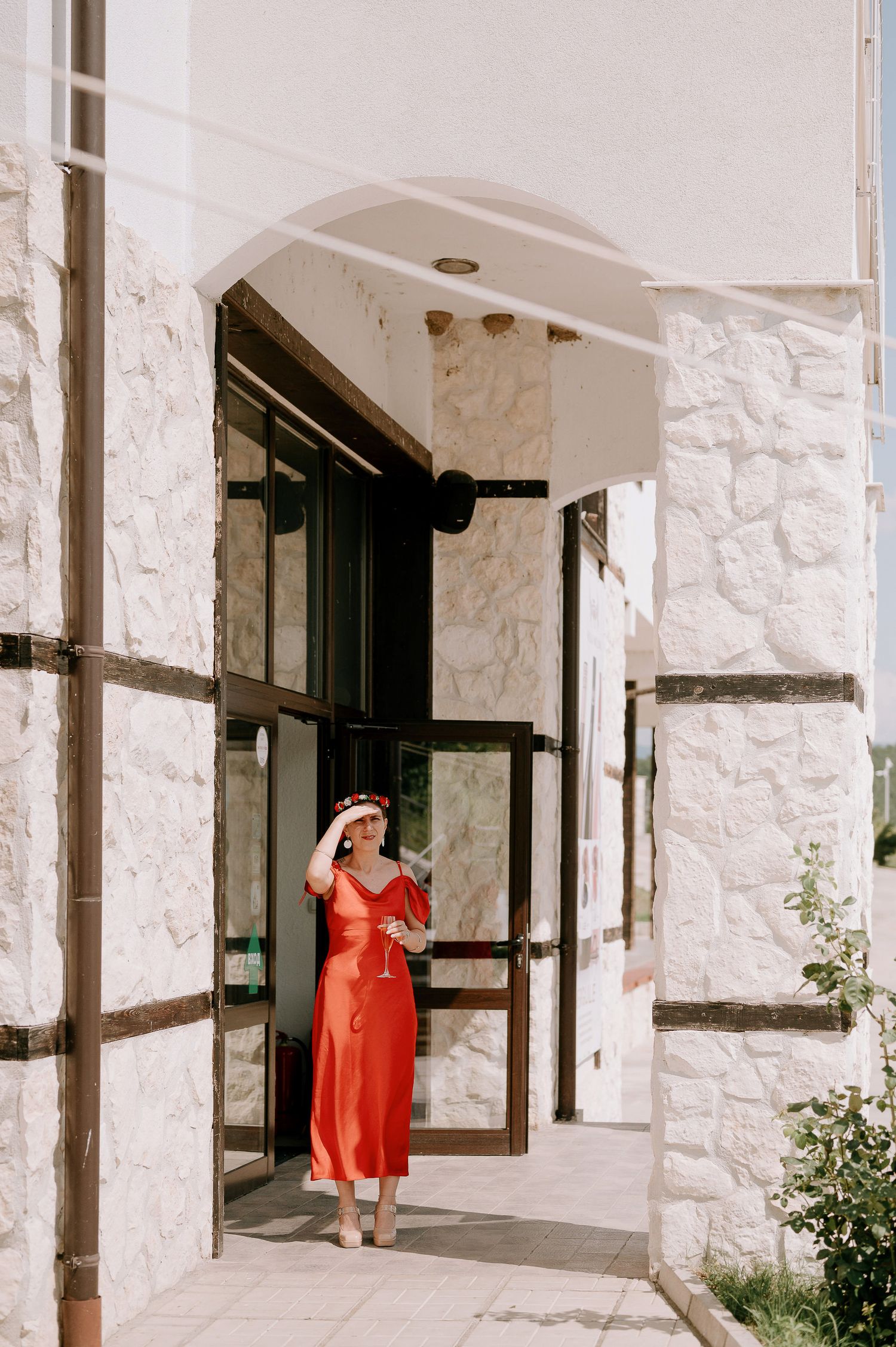 White stucco building exterior with arched doorways and textured stone walls.