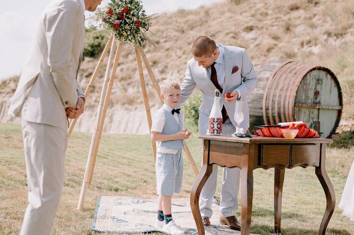 Rustic outdoor wedding reception details with wooden furniture and decorative elements.
