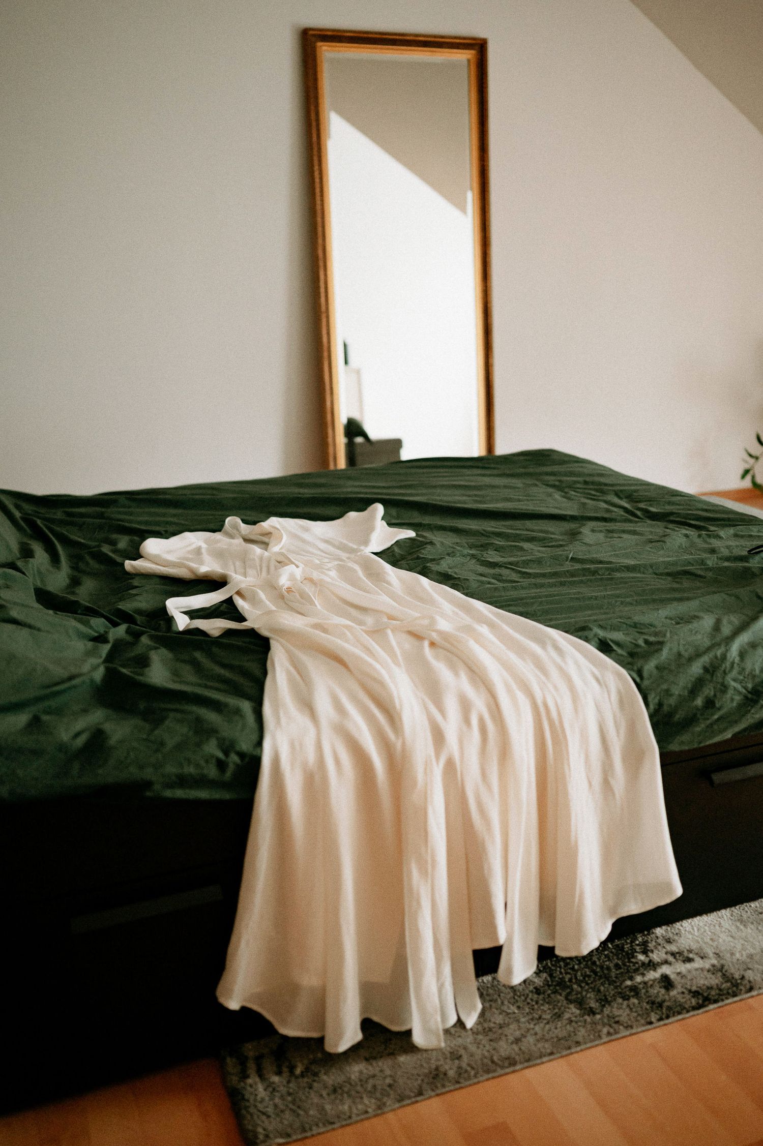 White fabric draped across dark green bedding in natural light.