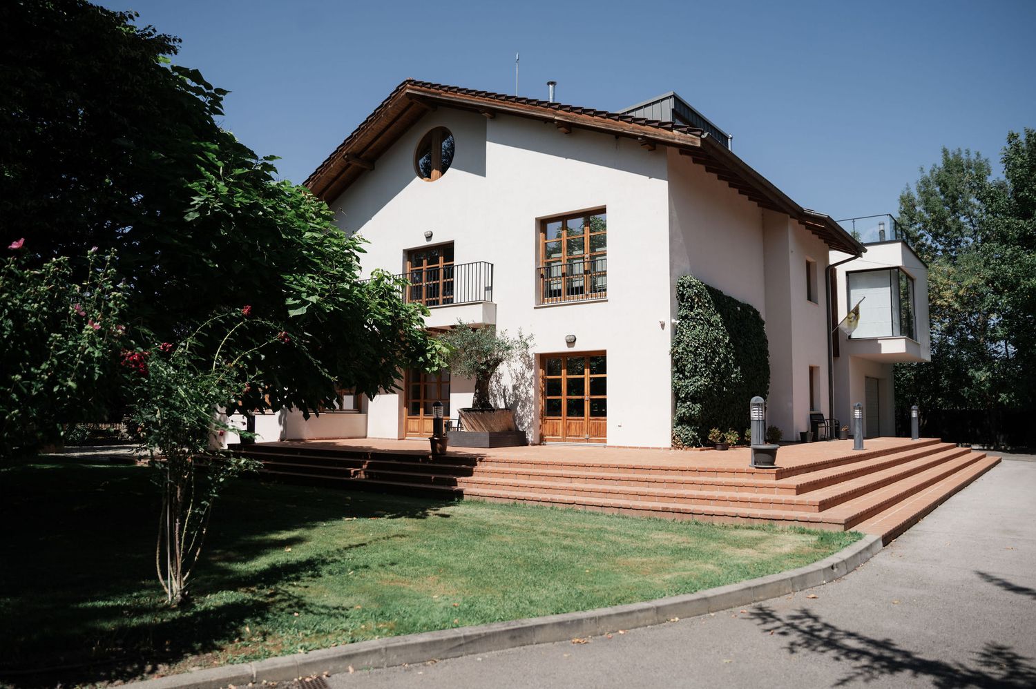 A series of connected photos showing a white Spanish-style building with terracotta roof tiles and manicured grounds.