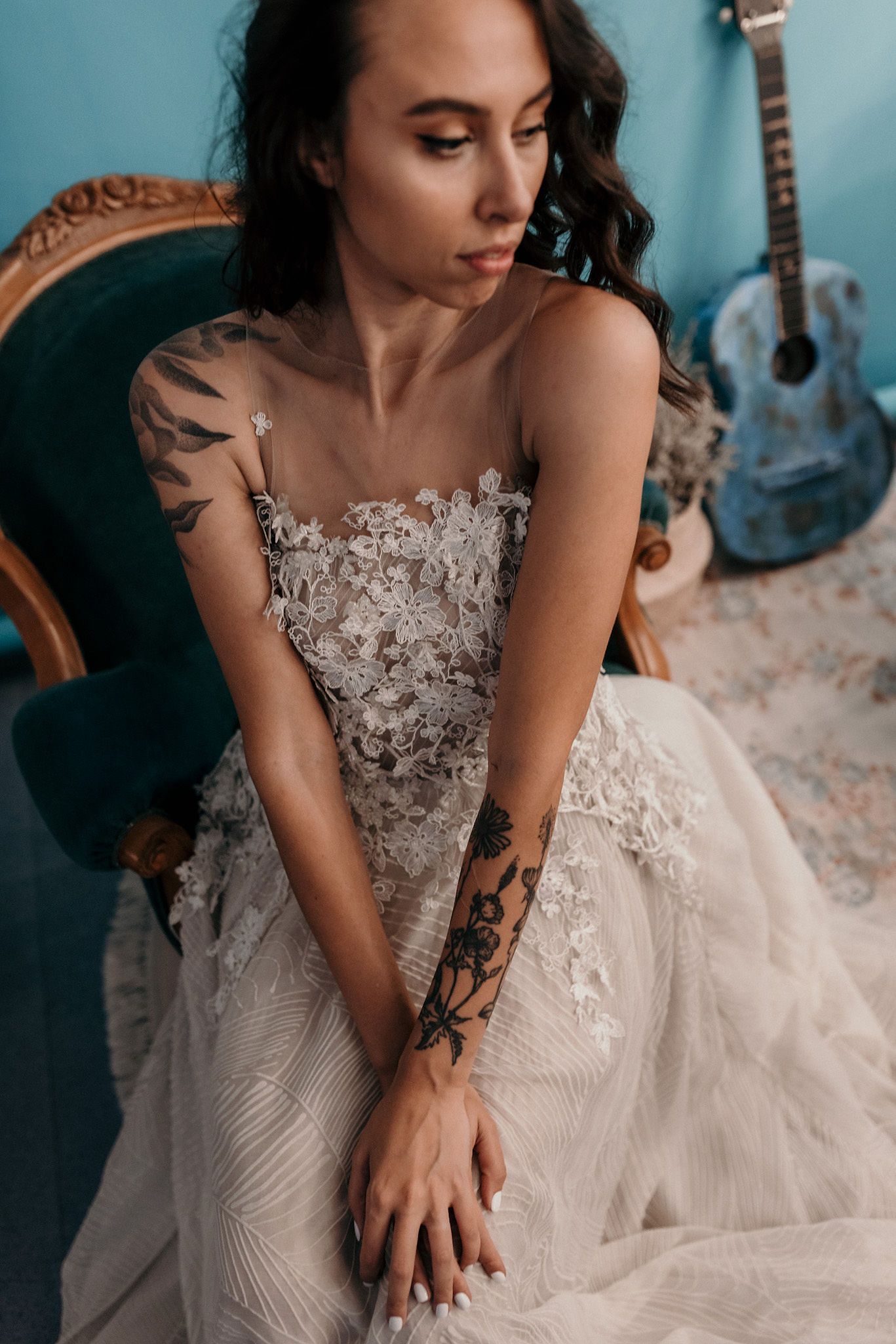 Elegant bridal portrait showcasing intricate lace bodice and floral arm tattoos.