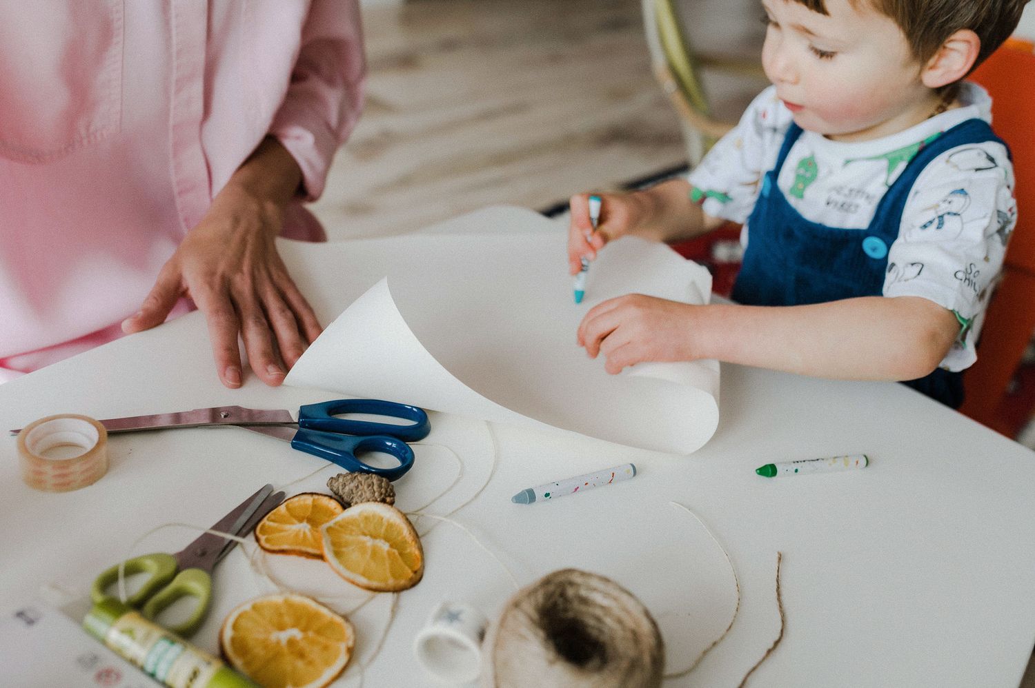 Children gather around a table for a cooking activity with ingredients and kitchen tools spread out for hands-on learning.