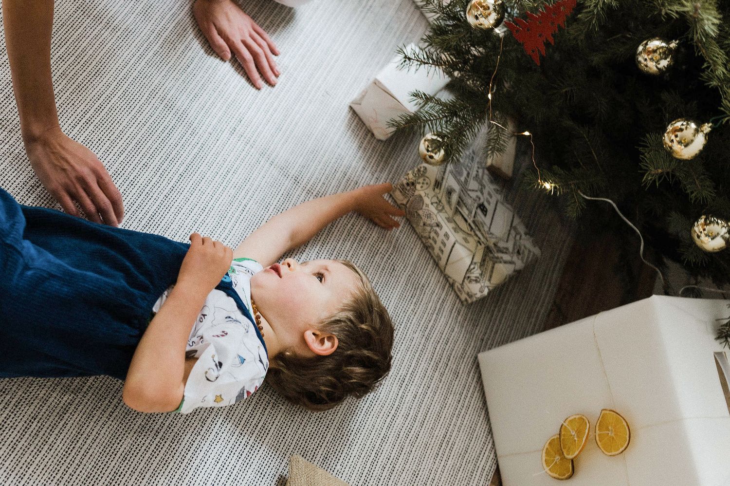 A series of candid lifestyle photos showing someone lying on a gray floor with scattered white flowers and oranges nearby.