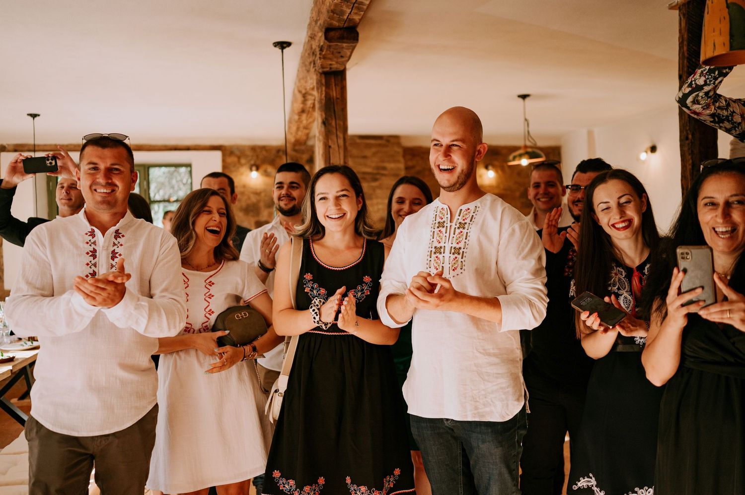 Wedding guests celebrate during reception with joyful expressions and casual attire.