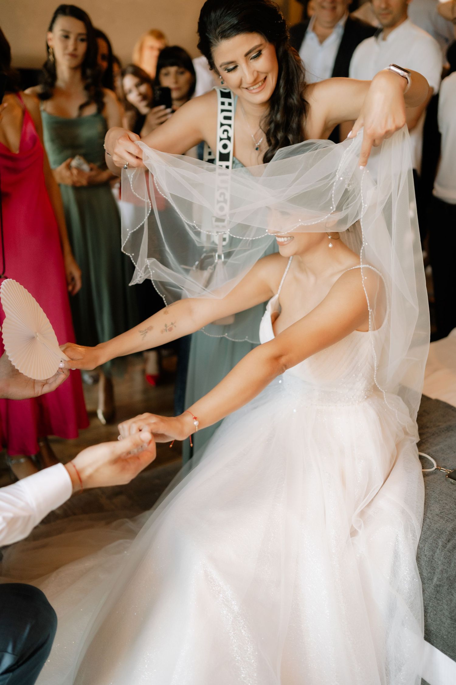 A flowing white wedding dress twirls gracefully during a dance as guests look on in the background.