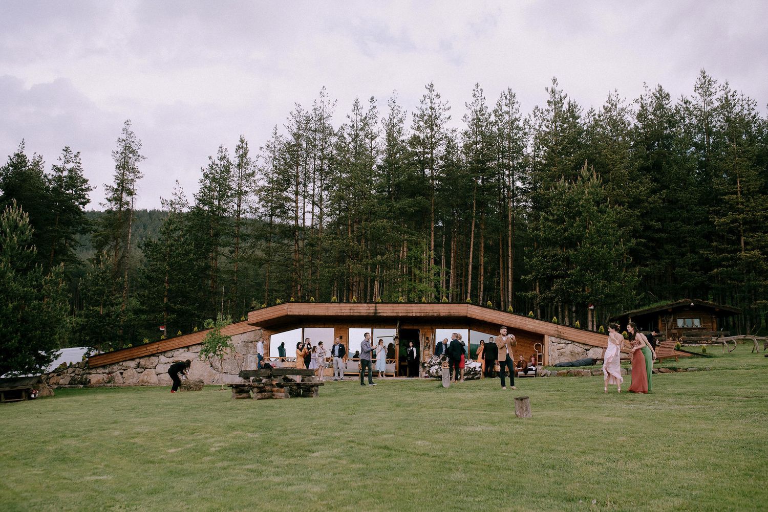 Panoramic view of wooden cabins and structures spread across a green hillside.