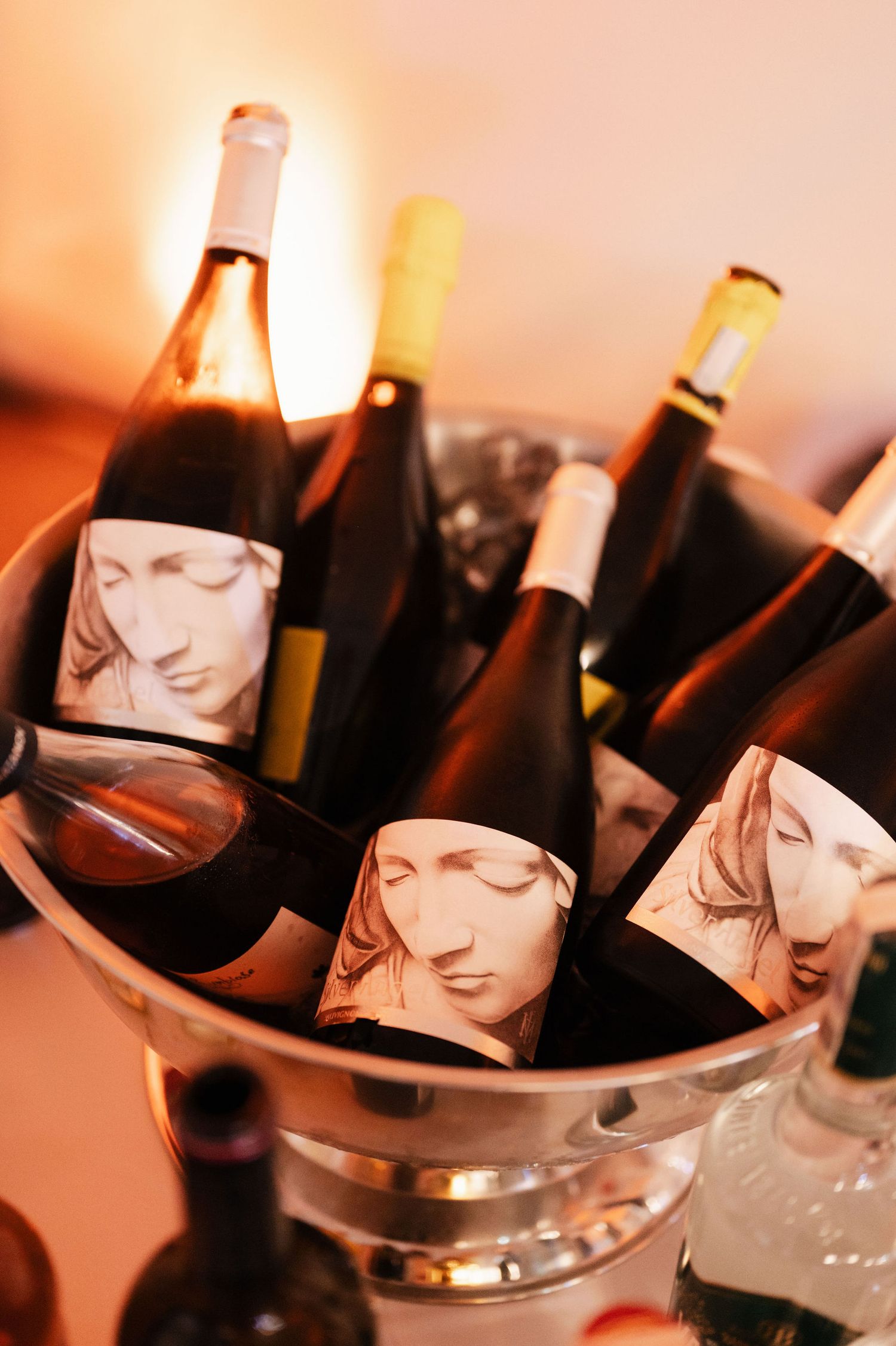 Chilled champagne bottles with distinctive black and white portrait labels resting in silver ice buckets.