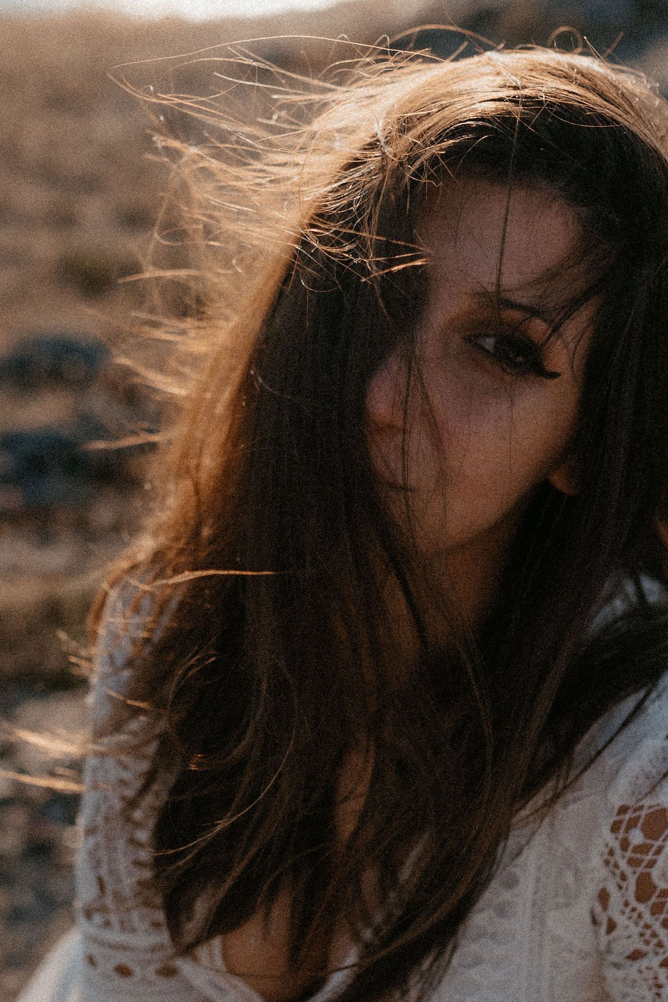 Windswept hair catching golden light during sunset photoshoot.