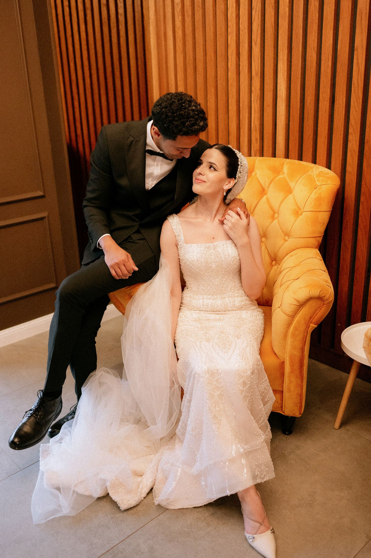 Indoor wedding photo sequence featuring tender moments against wood paneled walls and yellow furniture.