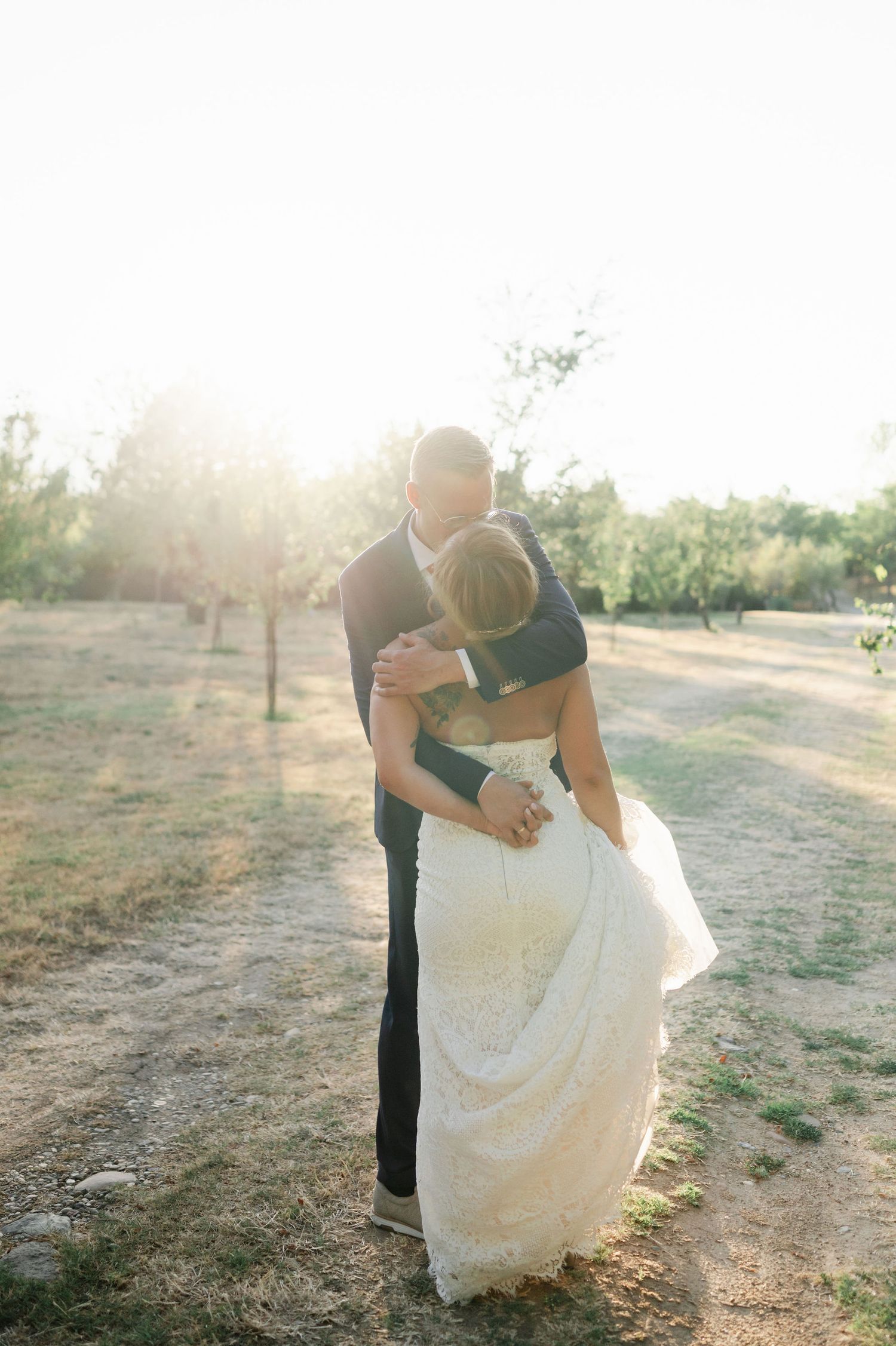 Romantic sunset wedding photos in outdoor orchard setting.