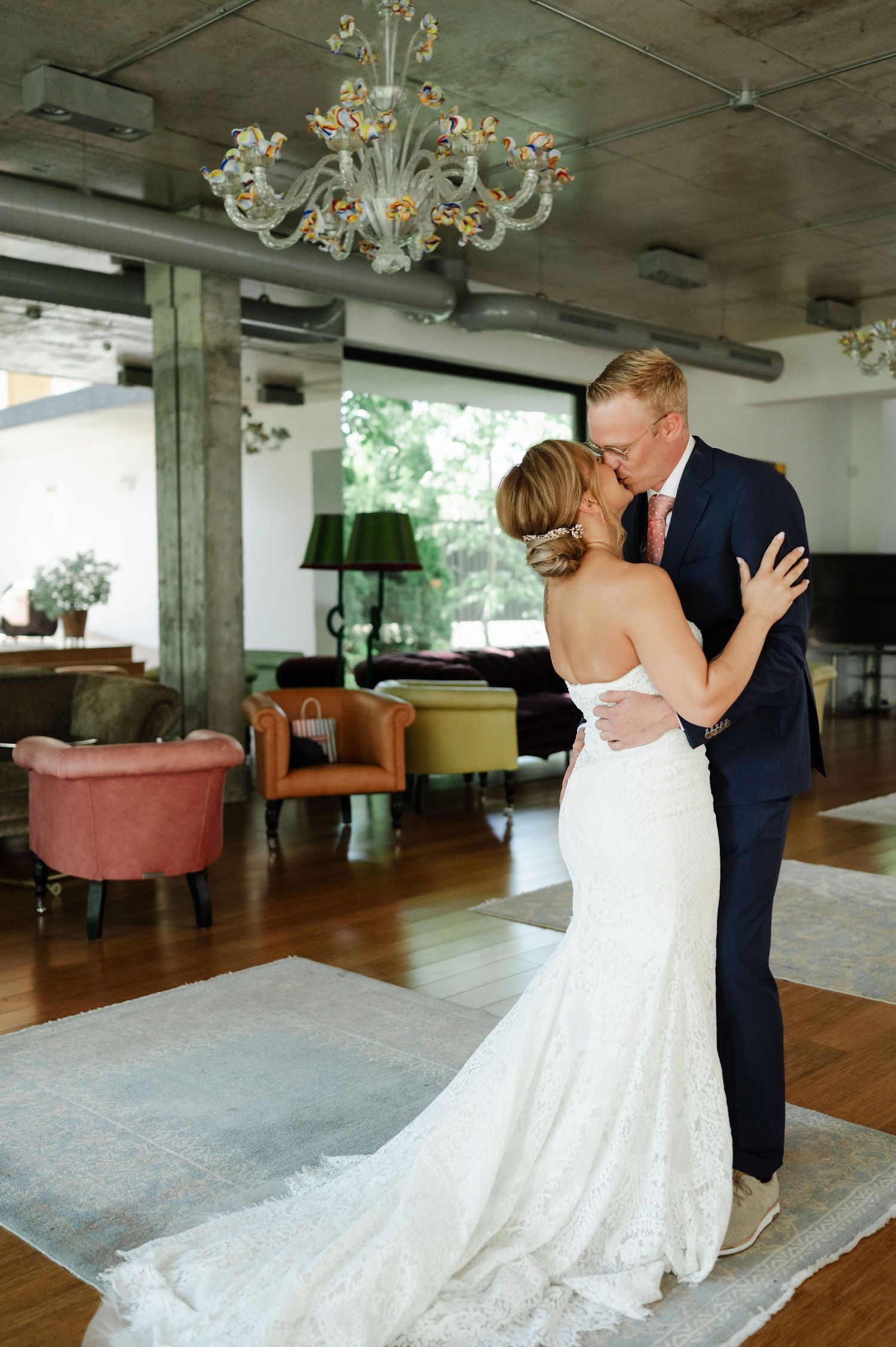 A romantic dance sequence in an elegant reception space with hardwood floors and vintage chandeliers.