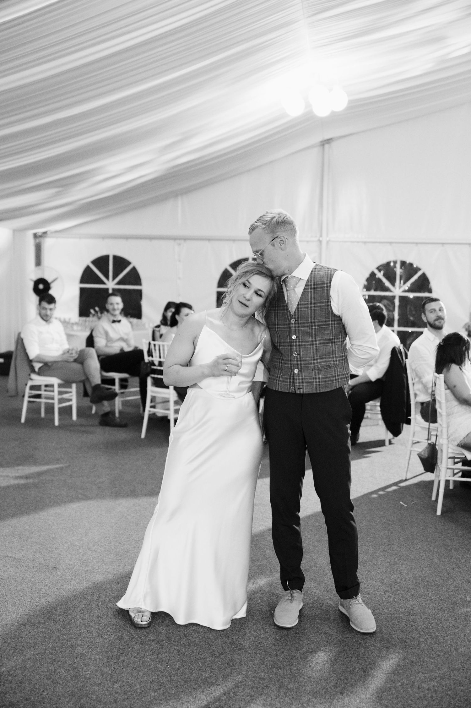A romantic black and white photo of a couple during their wedding reception.