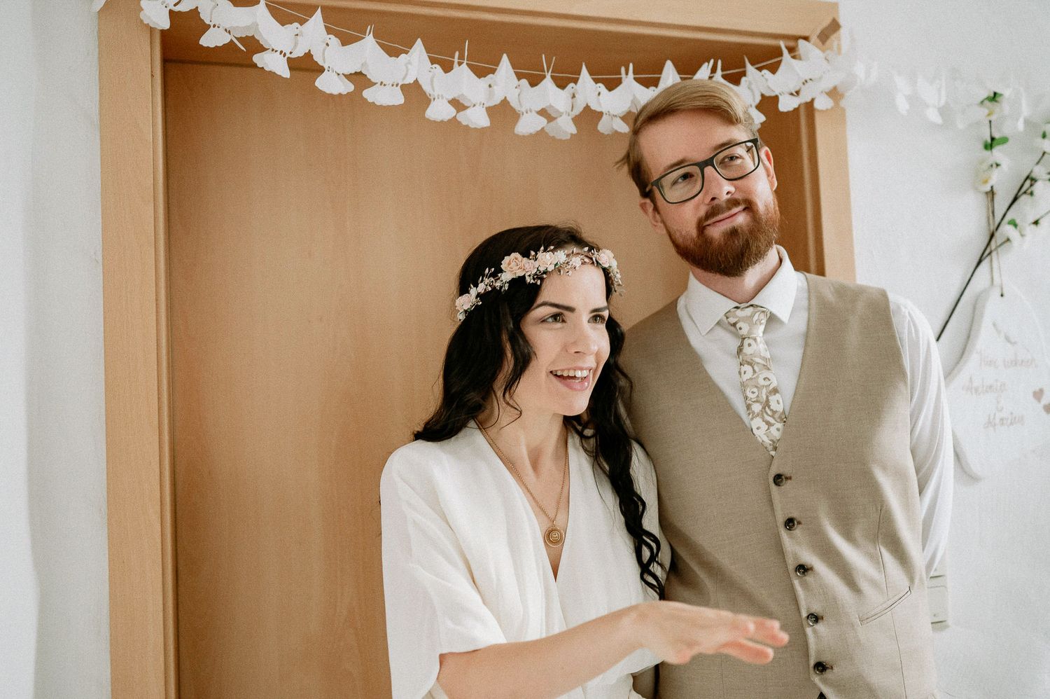 Wedding celebration under white paper lantern decorations in an intimate indoor setting.