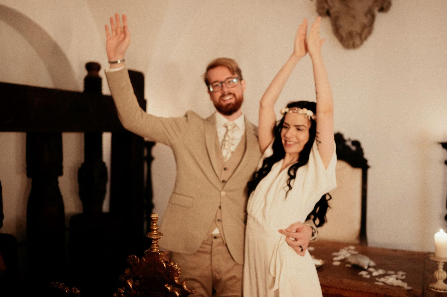 A joyful celebration moment captured in a rustic white room with vintage decor.