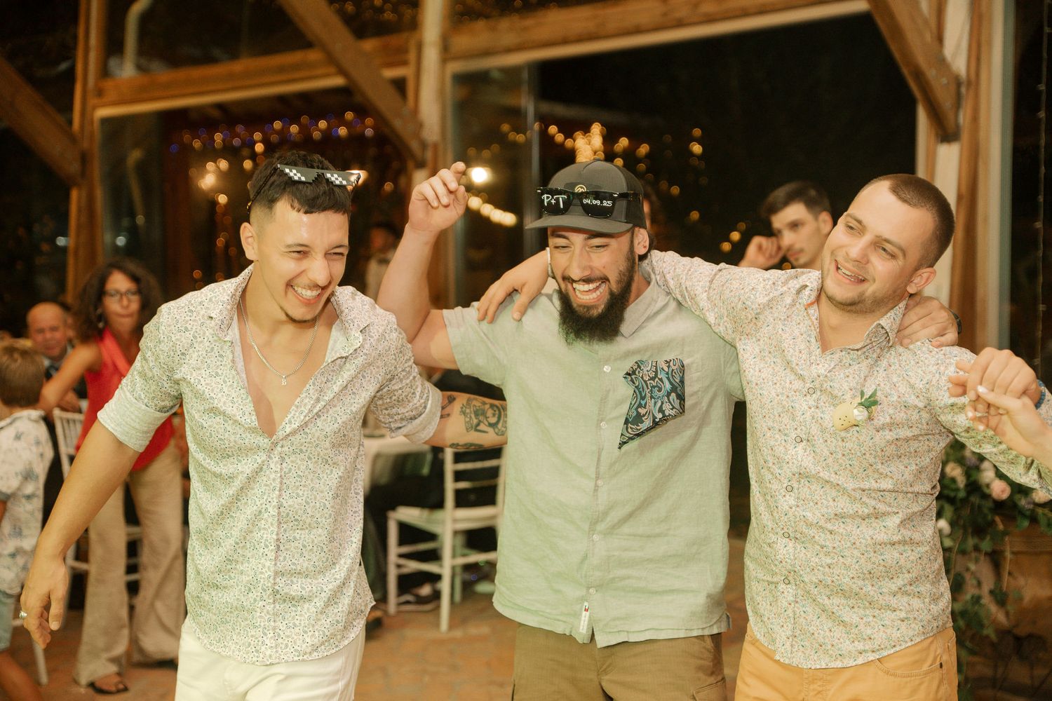 A group of people dancing and celebrating at a festive party with their arms raised in joy.