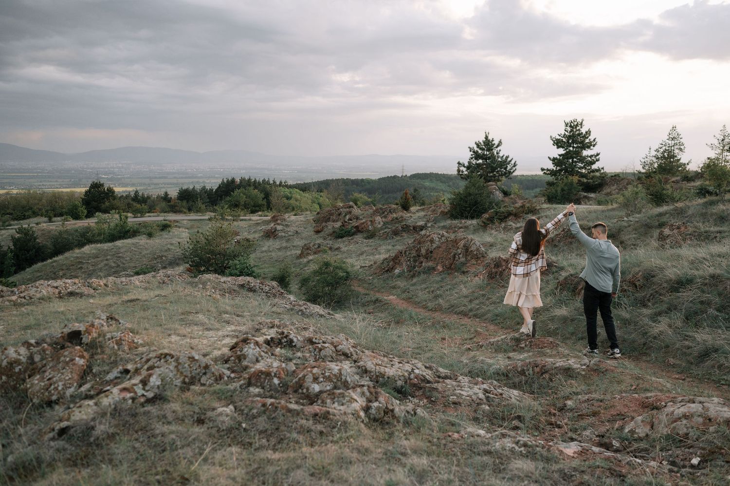 A sequence of landscape photos showing people walking through rugged desert terrain under cloudy skies at dusk.