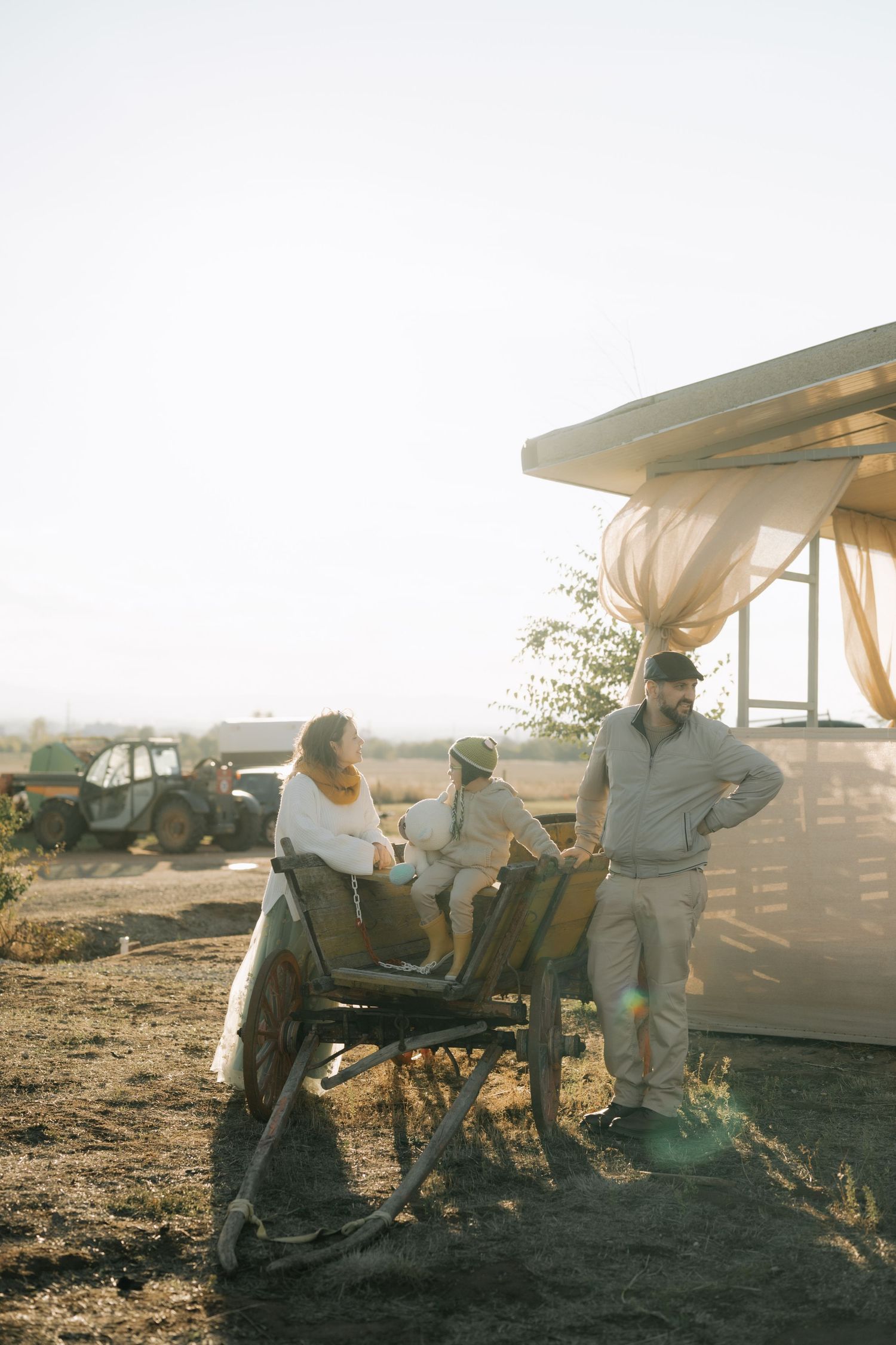 People relax in lounge chairs at sunset in a desert landscape with warm golden light filtering through.