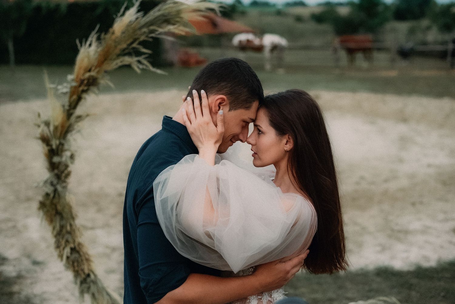 A tender moment between a couple during an engagement photo session in a rustic outdoor location.