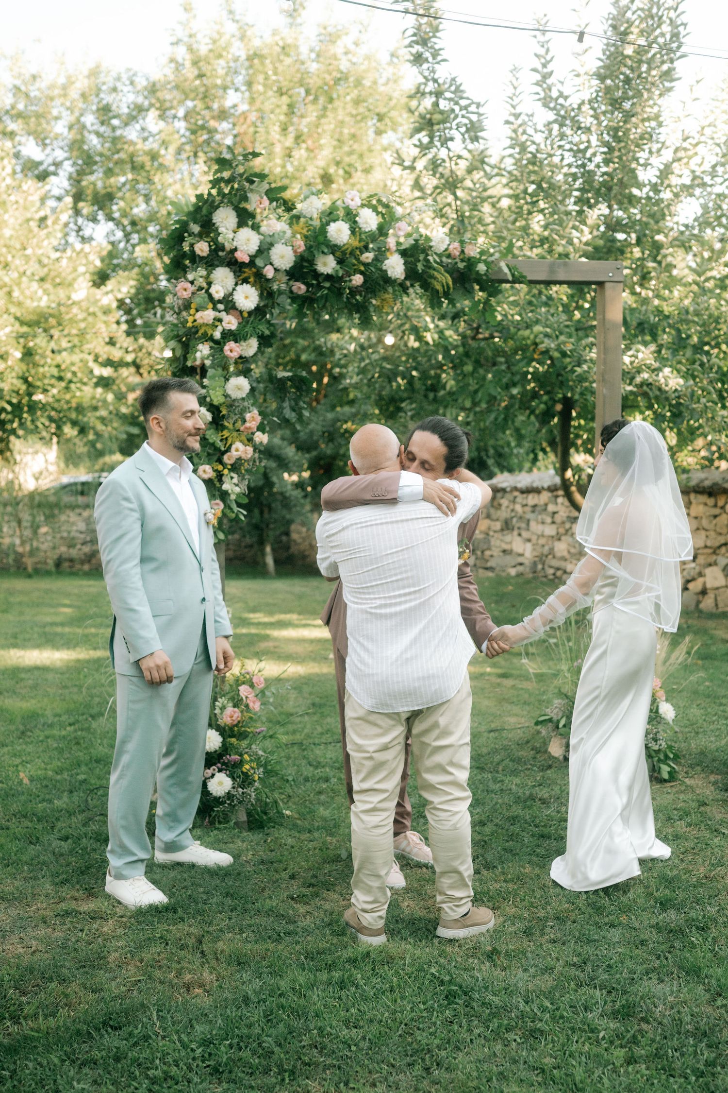 A sequence of four photos showing a couple dancing and twirling together in a sunlit garden setting.