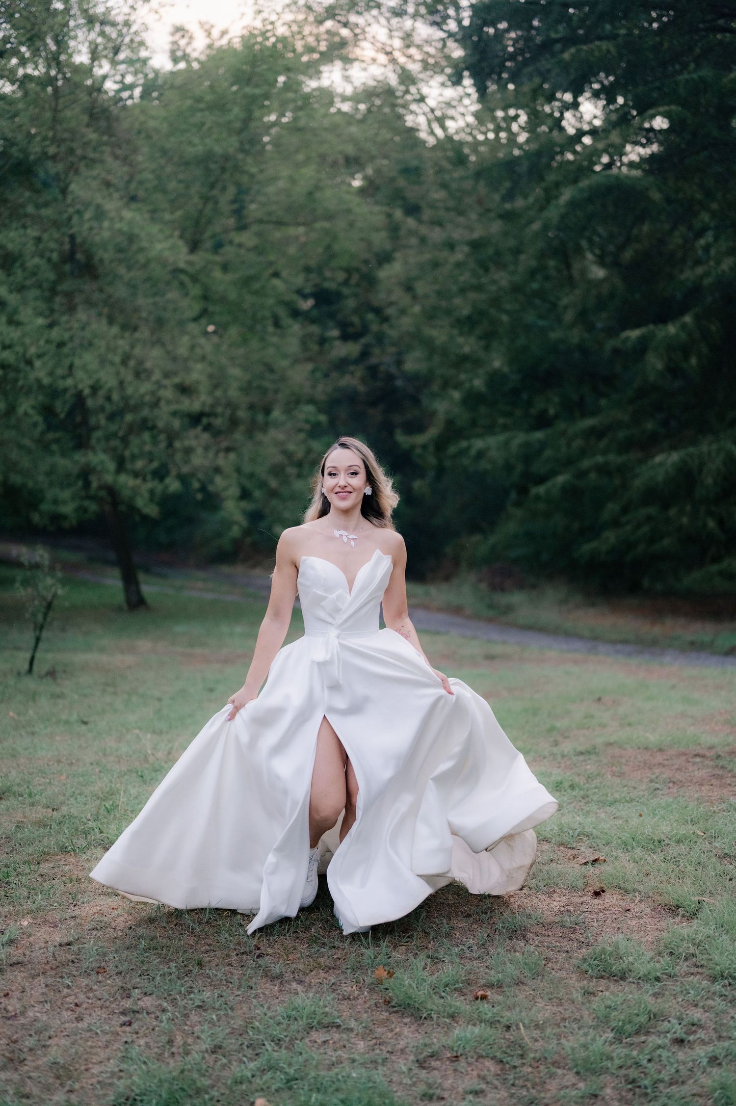 A series of artistic bridal portraits showing someone in a flowing white wedding dress sitting on grass in a park setting.