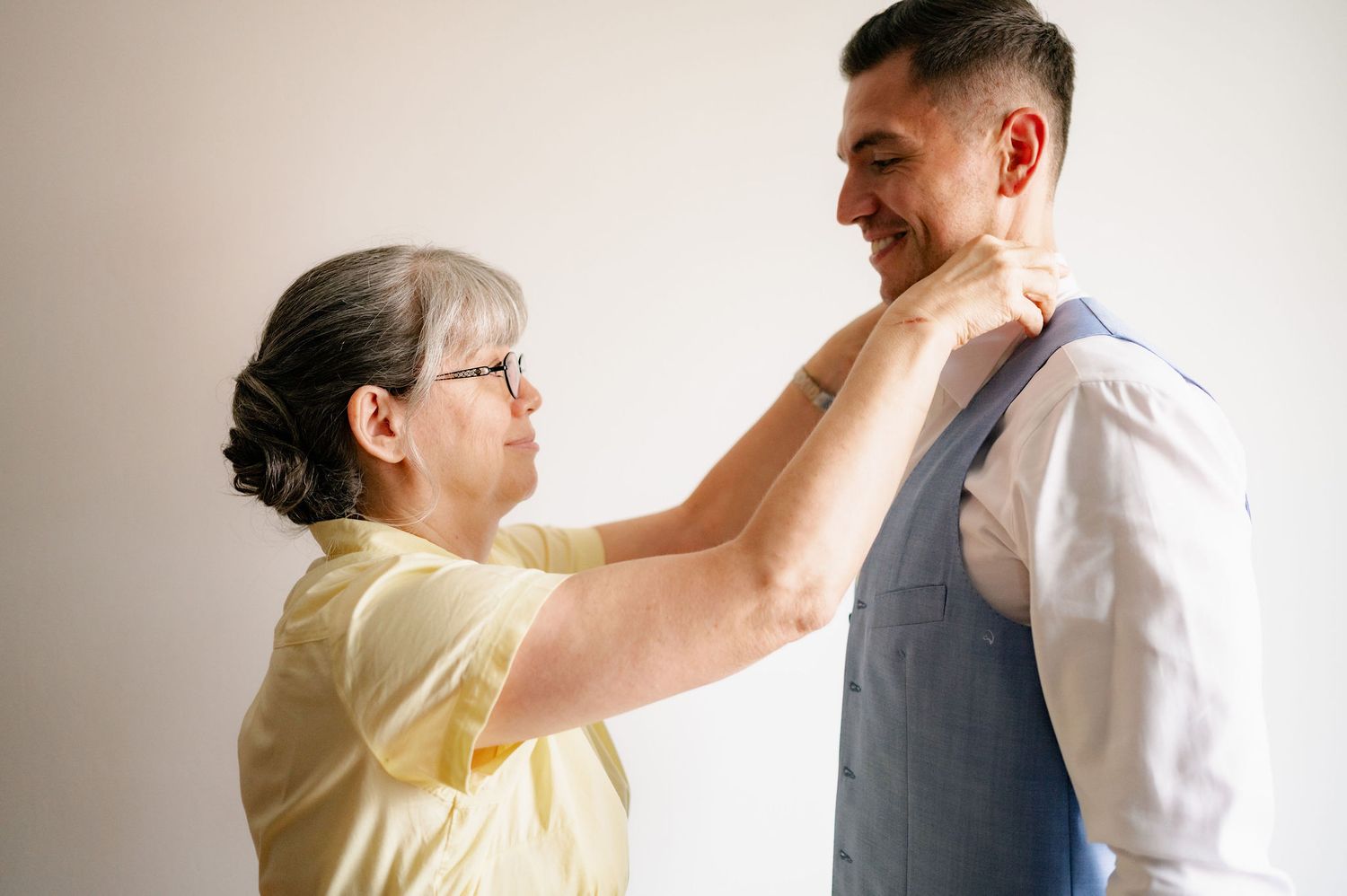 A sequence of seven images showing a tender moment between two people in white and yellow clothing.