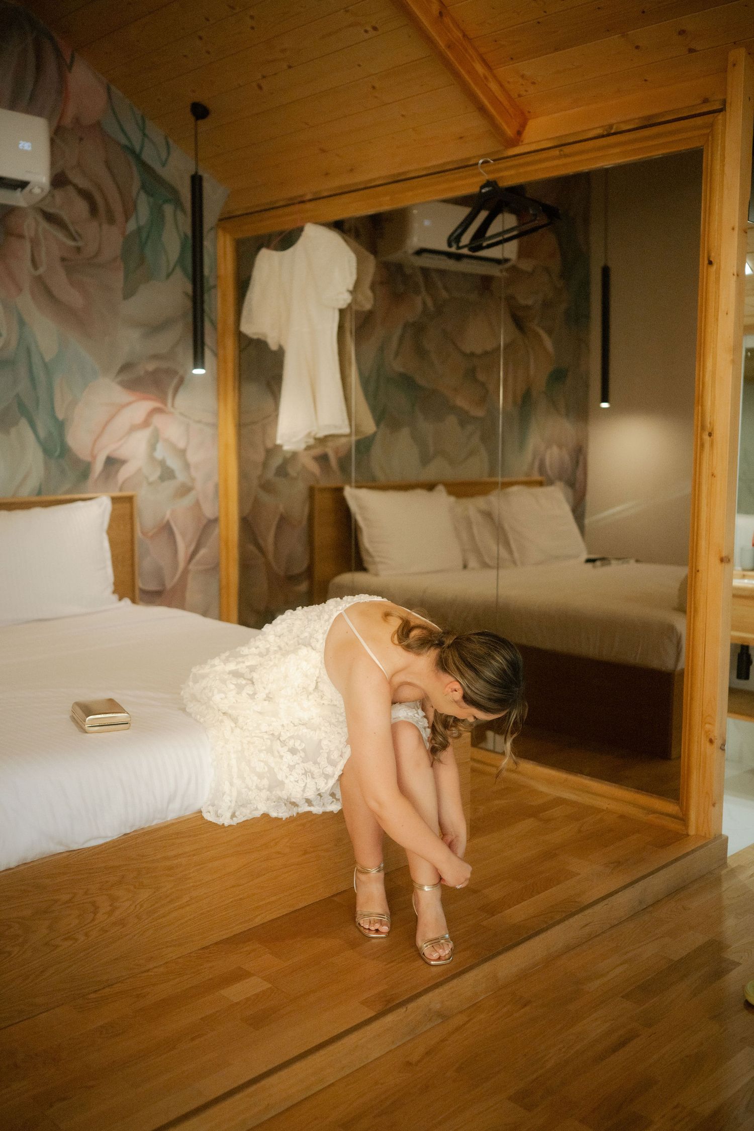 Four sequential photos show a person in white dress lying on a wooden floor beside a mirrored wall.