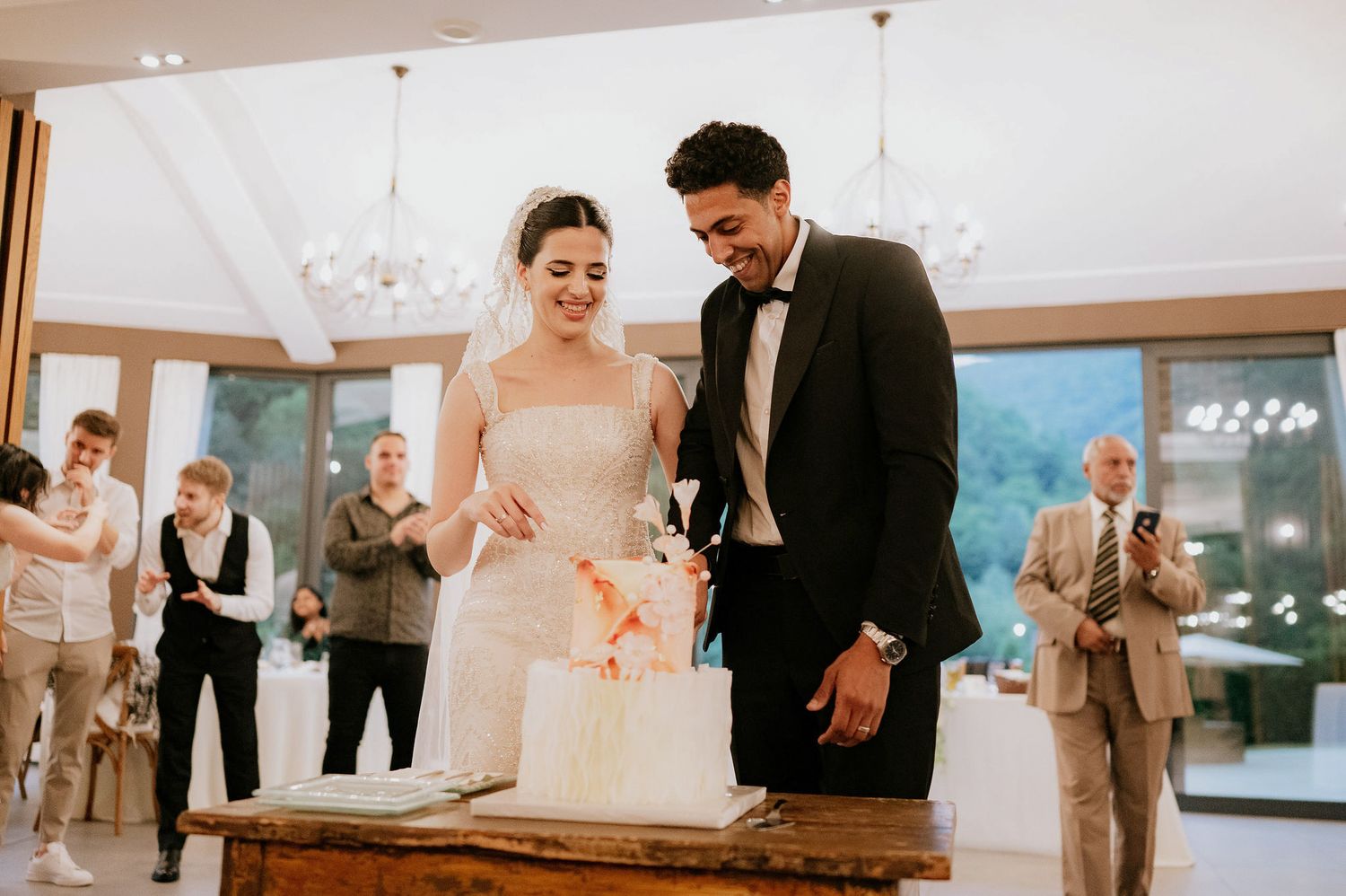 Couple sharing a moment during their wedding reception in an elegantly decorated ballroom.