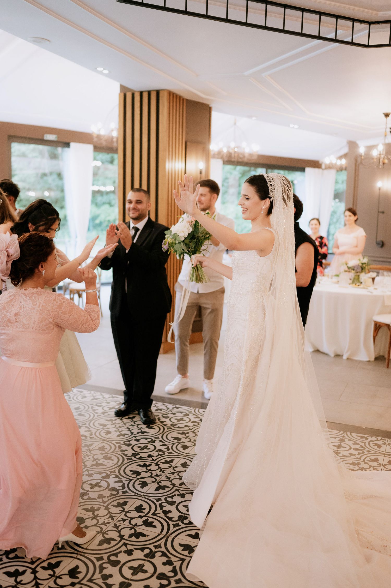Wedding reception dance floor with guests in pink dresses and formal attire.