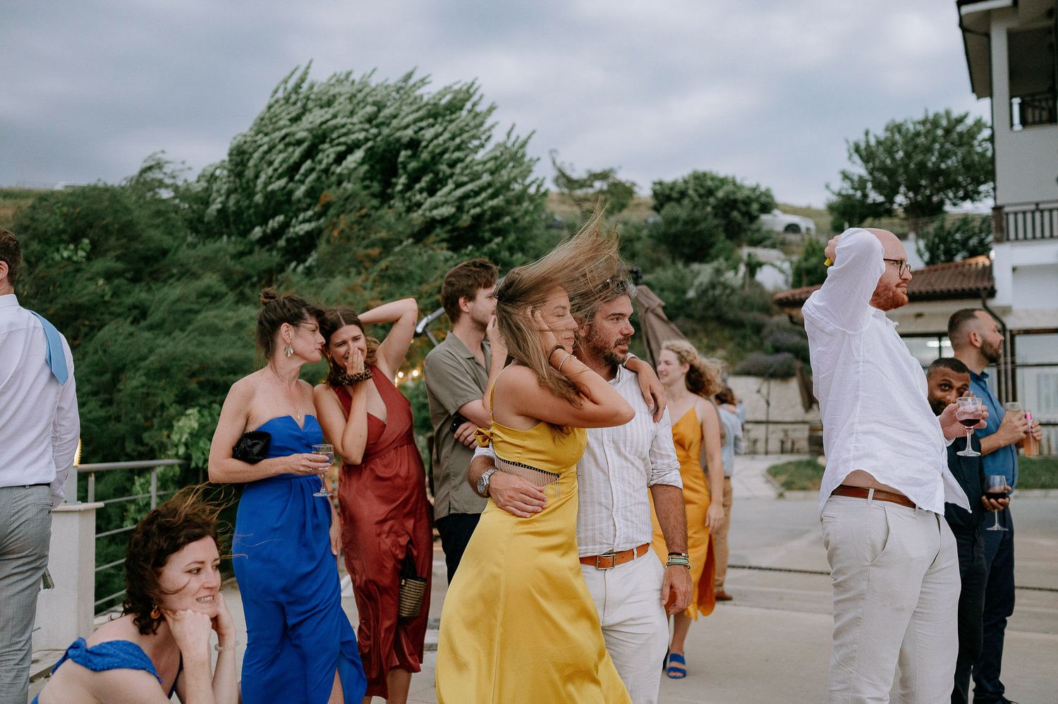 Wedding guests dance and celebrate at an outdoor reception.