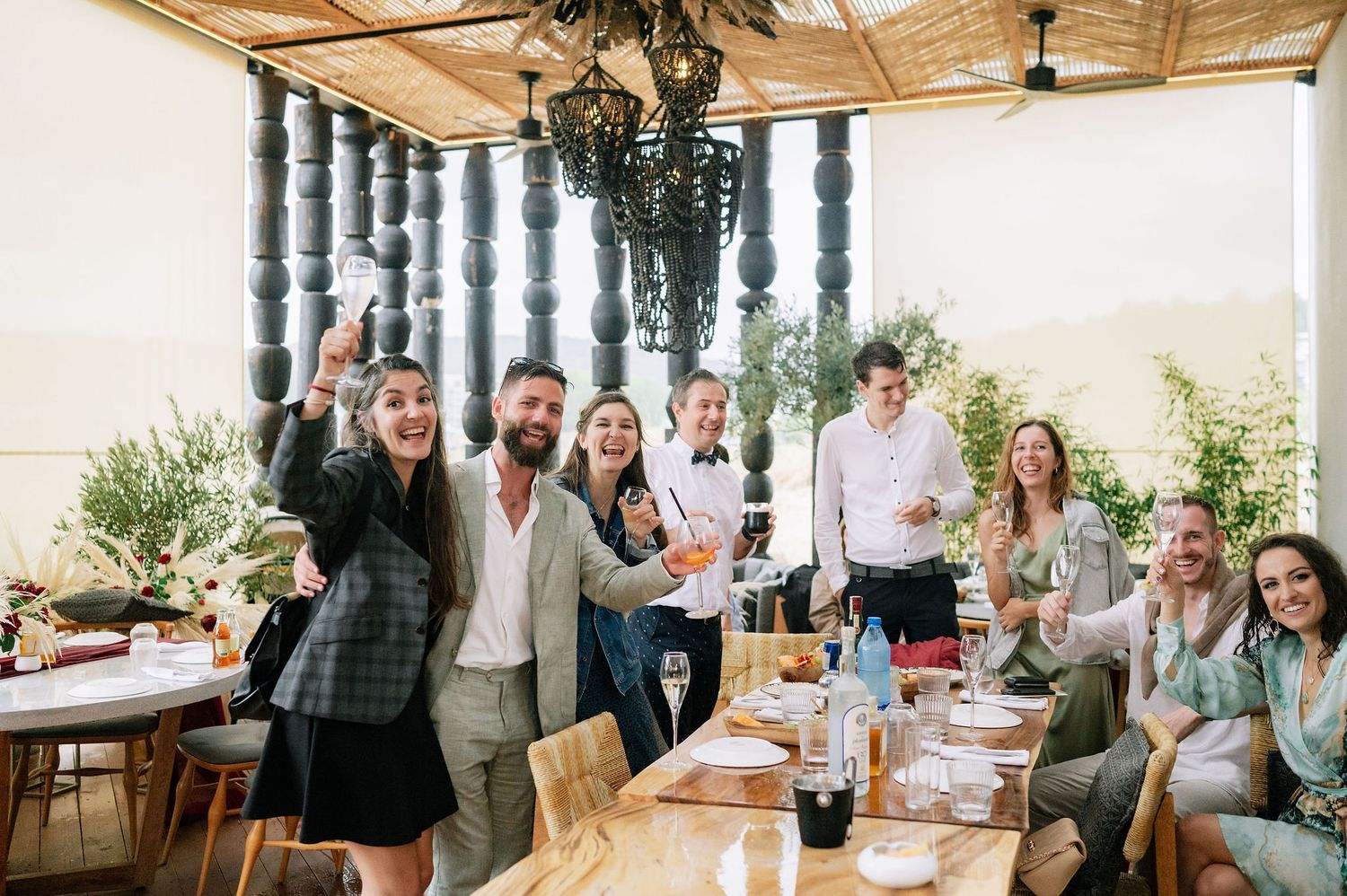 Indoor celebration with guests gathered in a rustic venue with wooden ceiling beams.