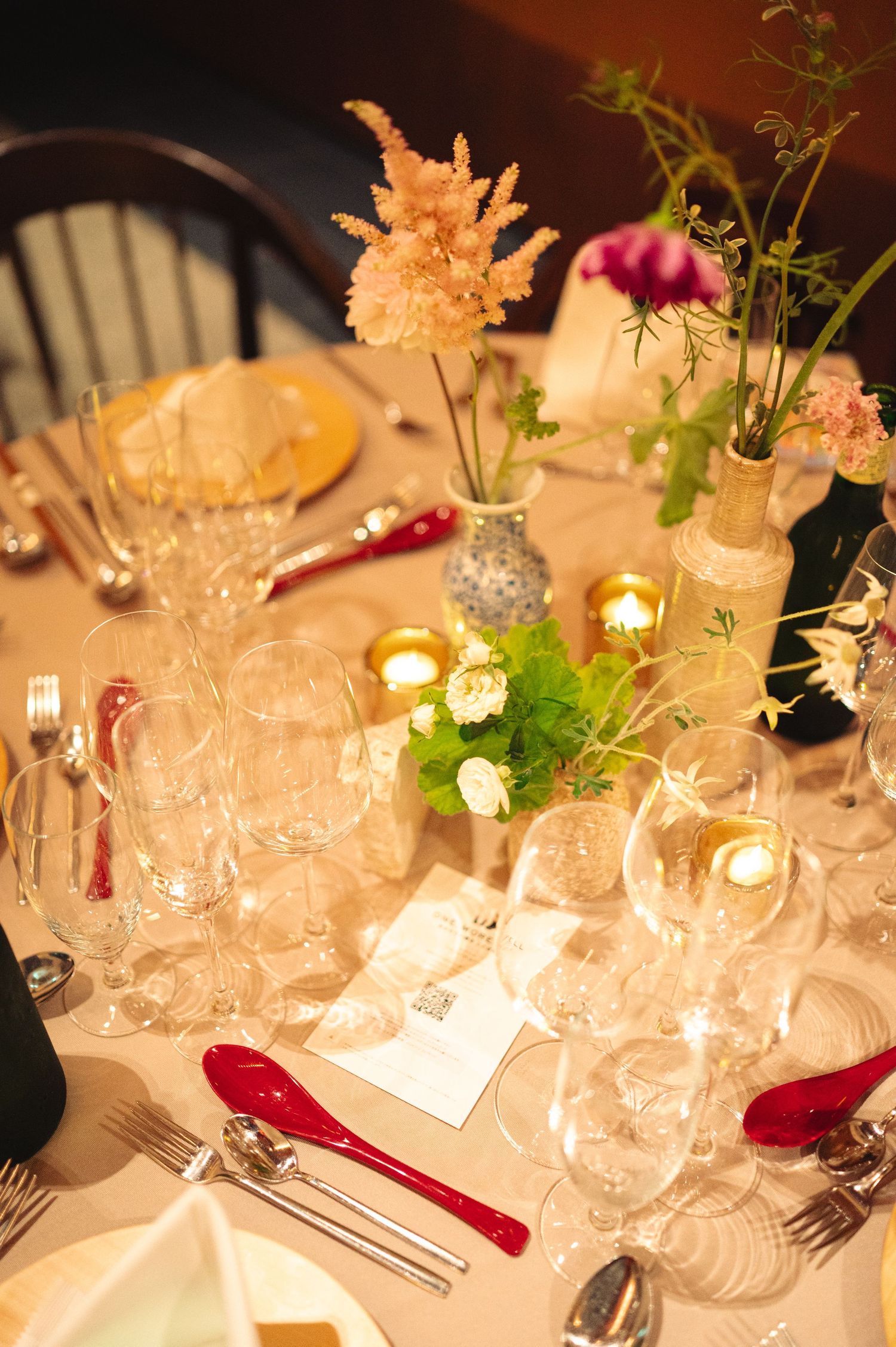 Close-up of formal place settings with crystal glassware and delicate floral arrangements.