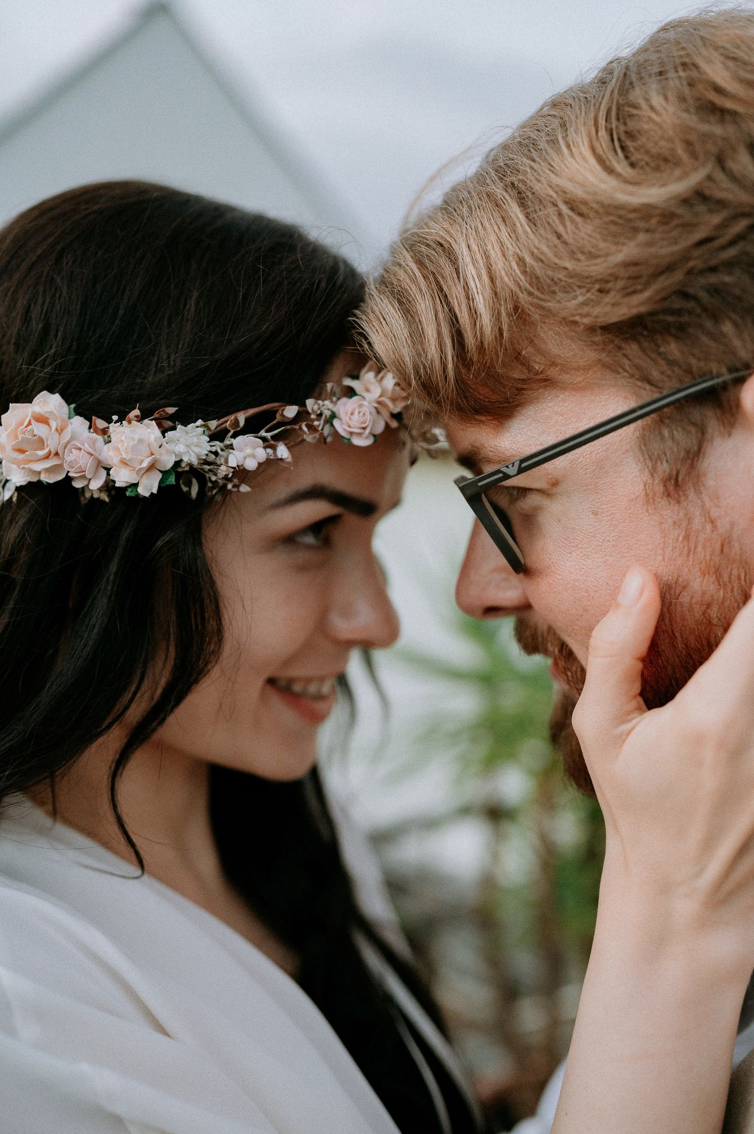 A close-up of newlyweds sharing an intimate moment outdoors.
