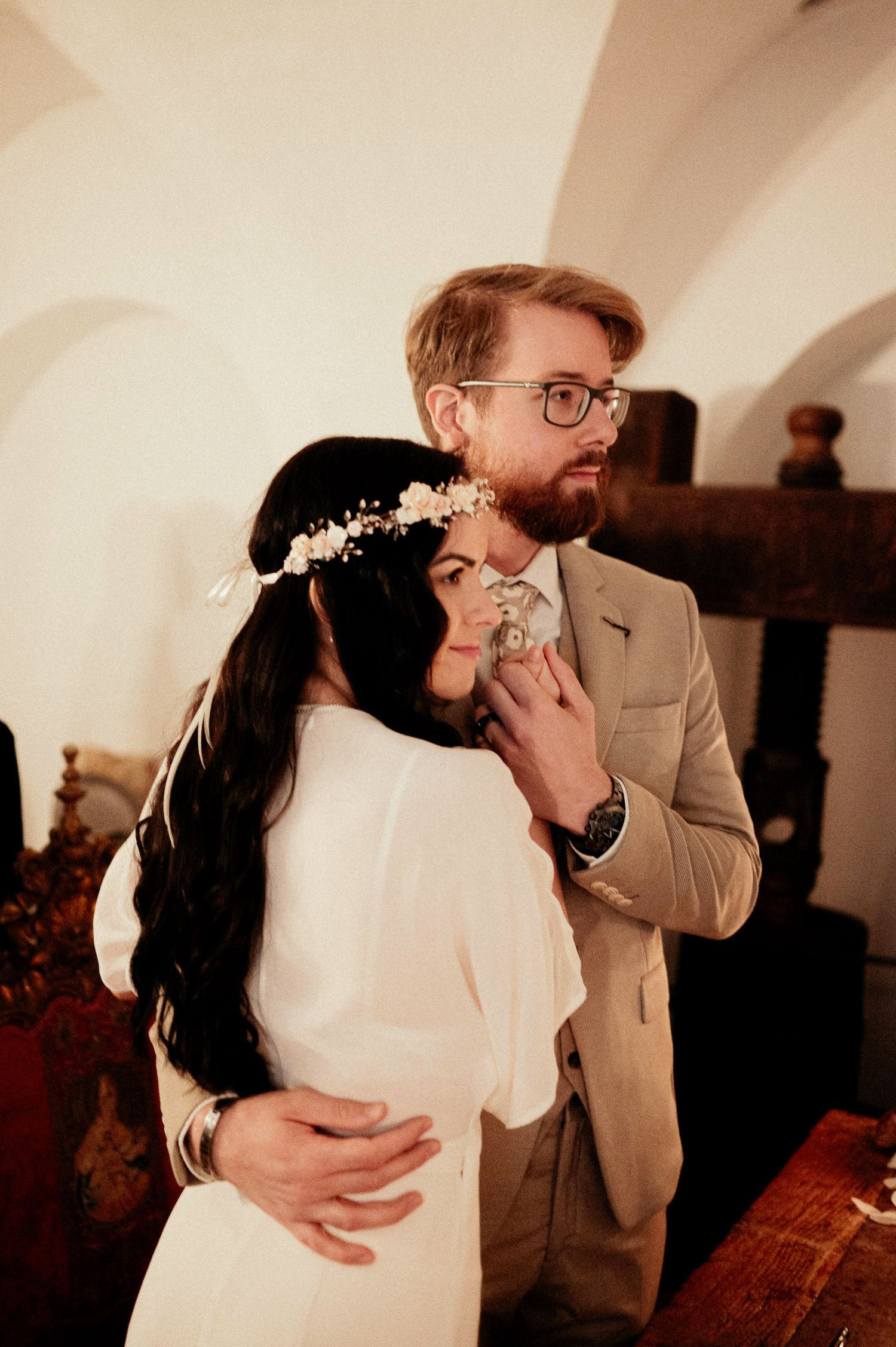 Romantic moment captured during intimate indoor ceremony with candlelight.