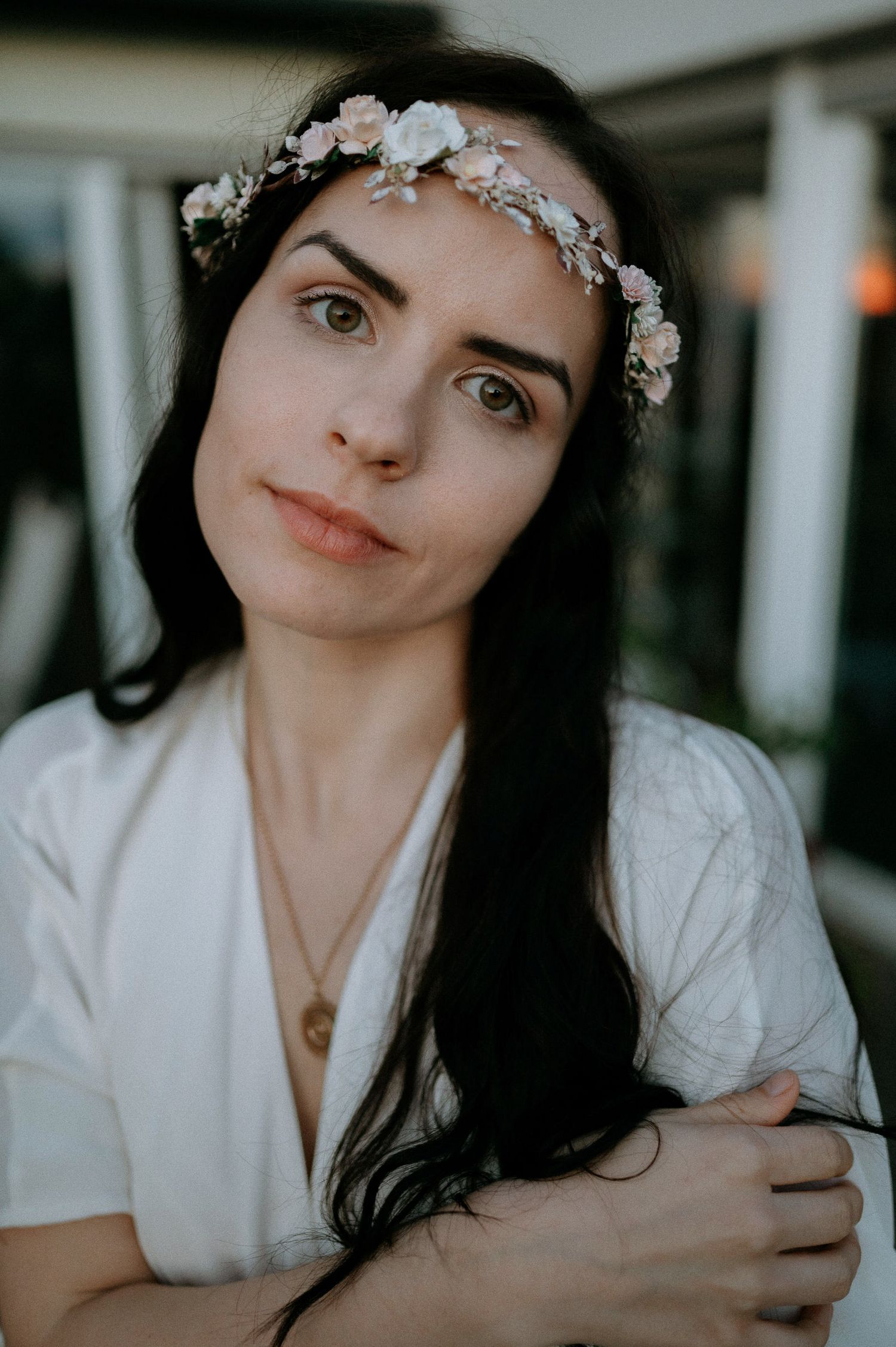 Person in white dress and floral crown poses for intimate portrait shots.