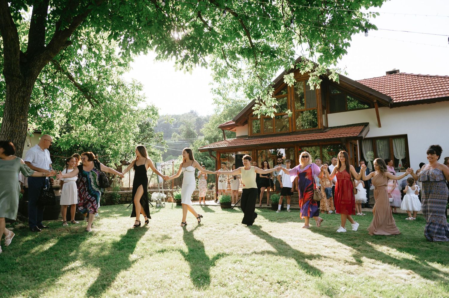 Wedding celebration at a rustic wooden lodge with guests enjoying the outdoor setting.